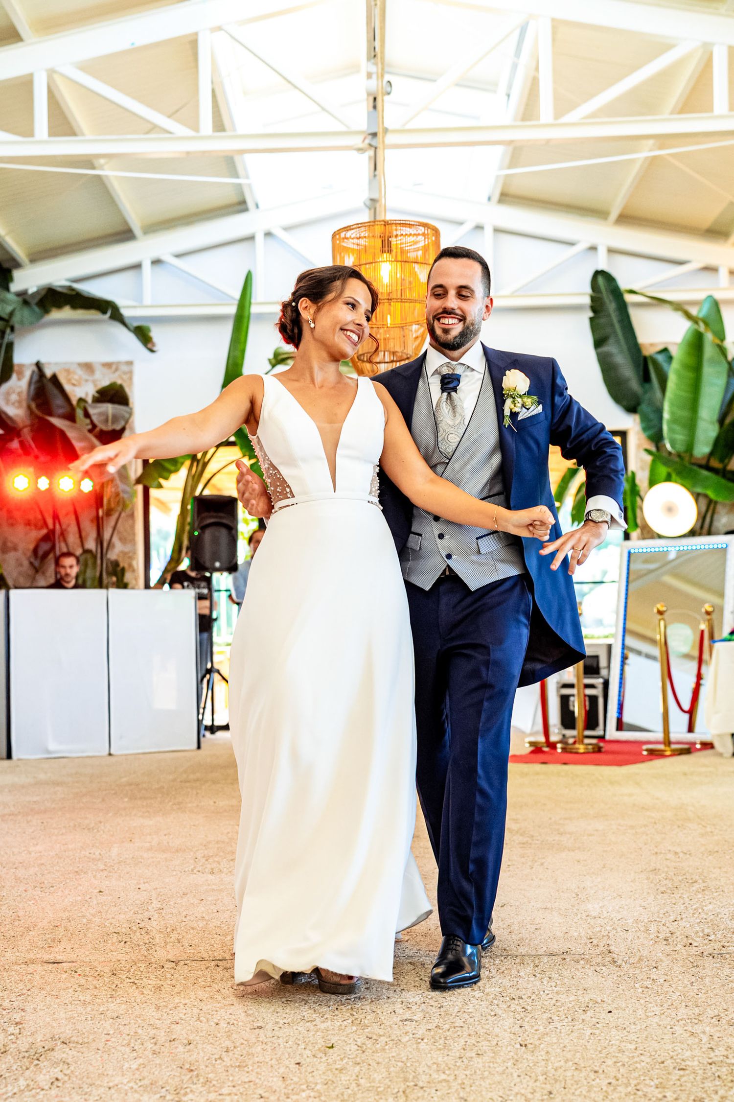 Smiling bride and groom sharing their first dance at a tropical wedding reception venue.