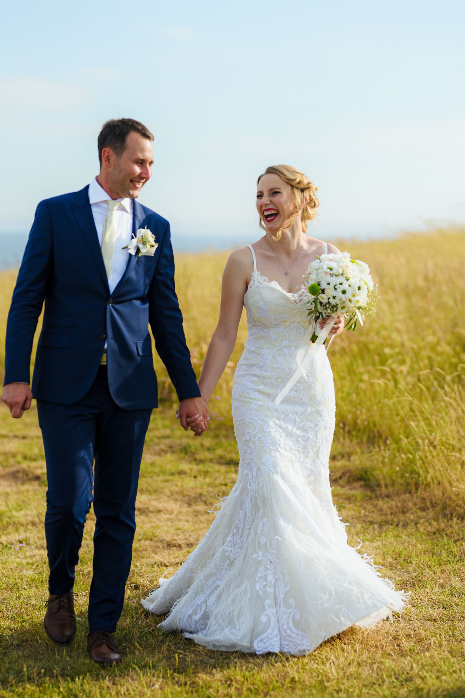 Joyful bride and groom walking hand in hand outdoors, natural wedding photography by Herzenshaus Studio, Frankfurt Rhein-Main.