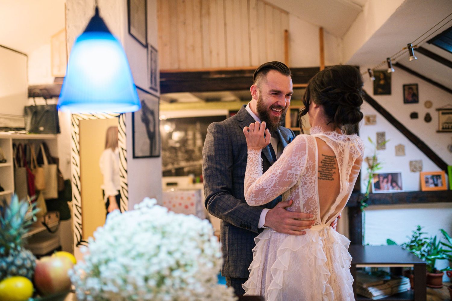 Bride and groom sharing tender first look moment in cozy rustic interior.