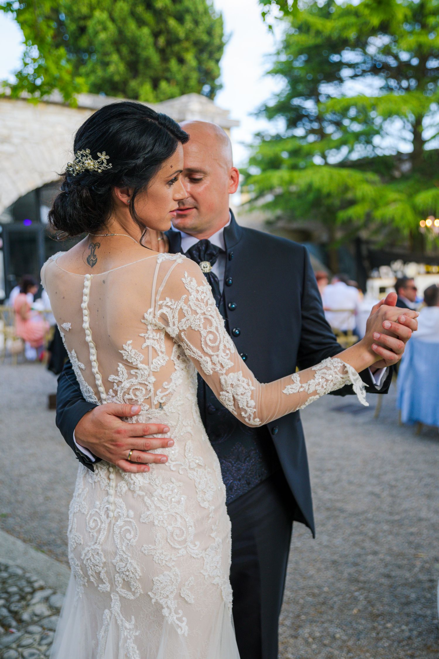 Bride and groom share their first dance, bride wearing elegant lace long-sleeve wedding gown.