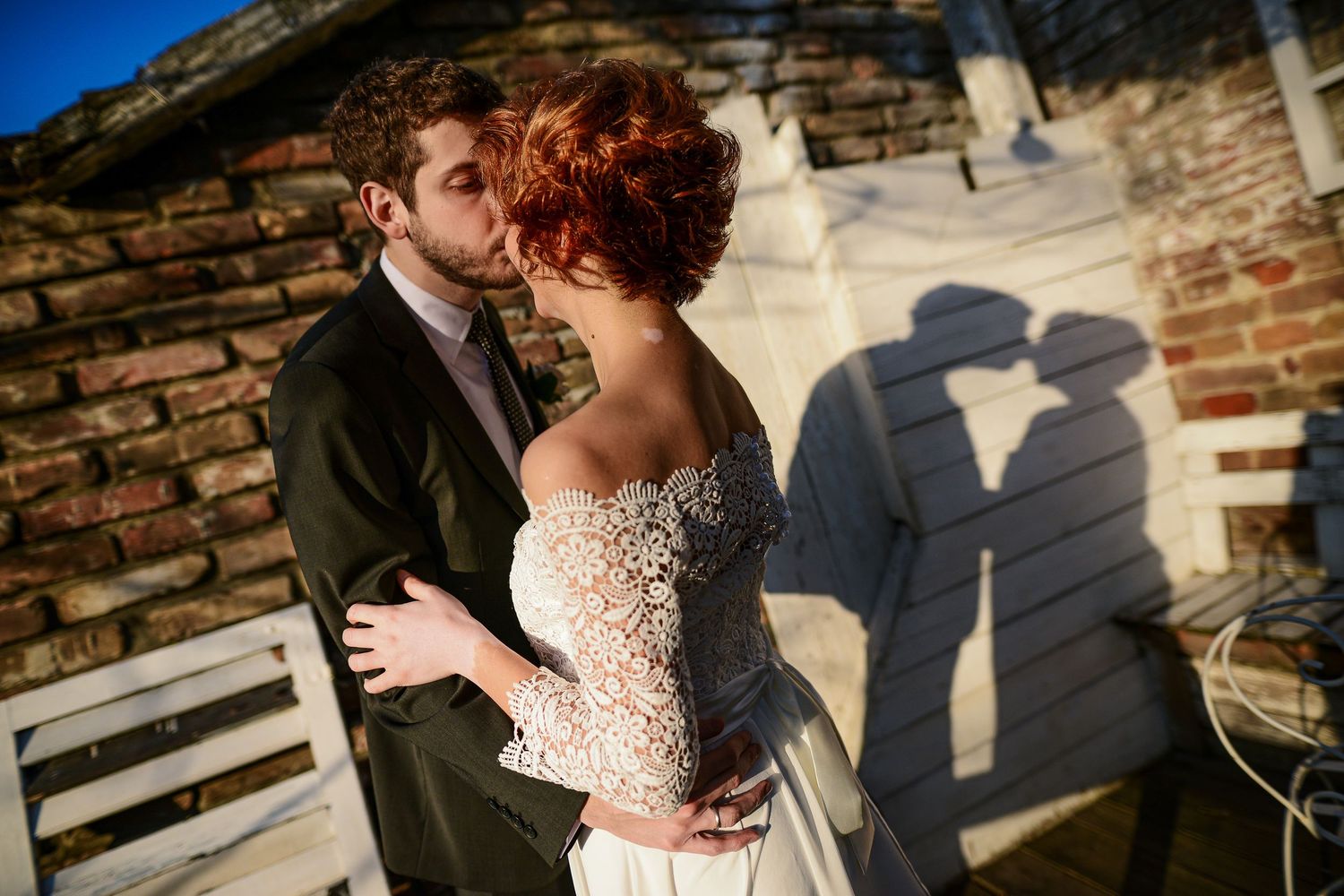 Bride and groom kissing as their shadows echo the moment - a cinematic wedding photograph by Herzenshaus Studio, Frankfurt Rhein-Main.