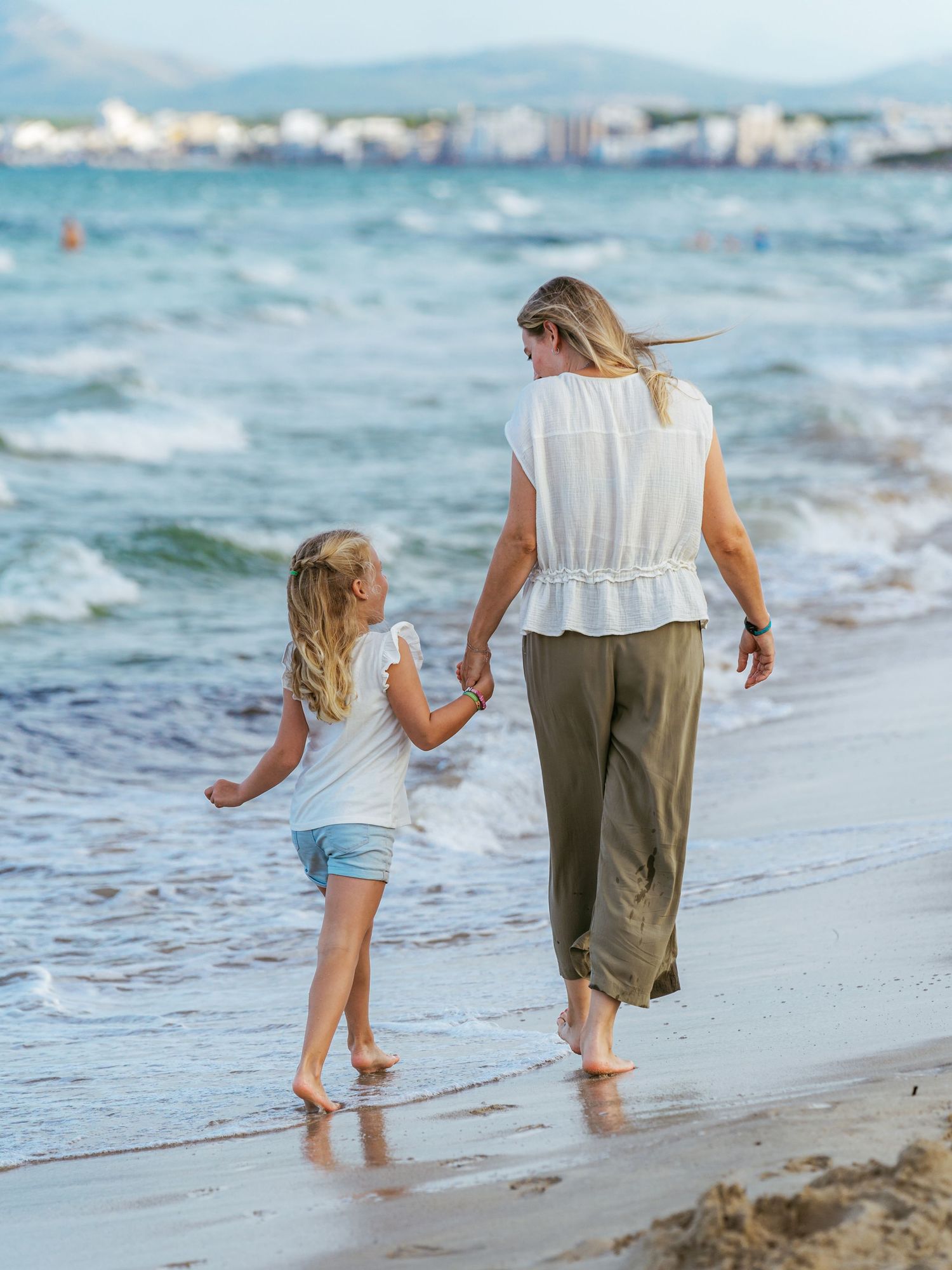 Mother and daughter walking hand in hand along the beach, natural family photography by Herzenshaus Studio, Frankfurt Rhein-Main.