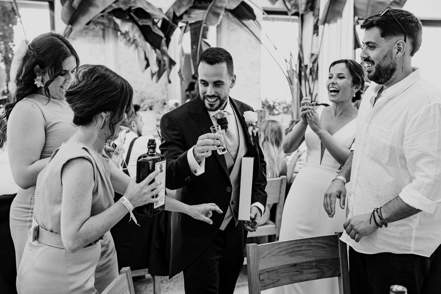 Groom celebrating with guests at outdoor wedding reception party.