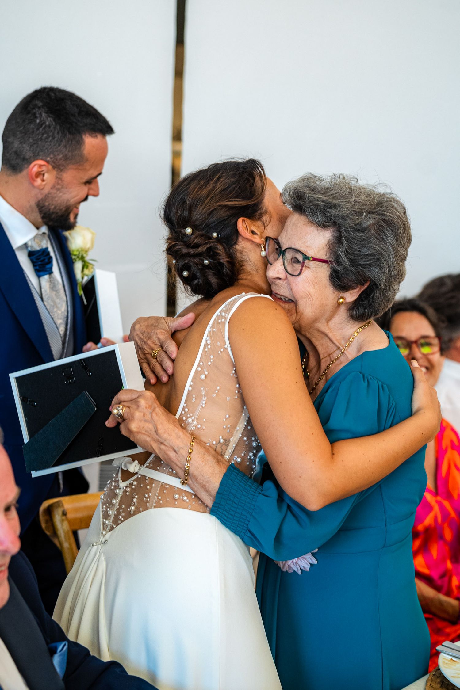 Bride receives a heartfelt hug from an older female guest following the wedding ceremony.
