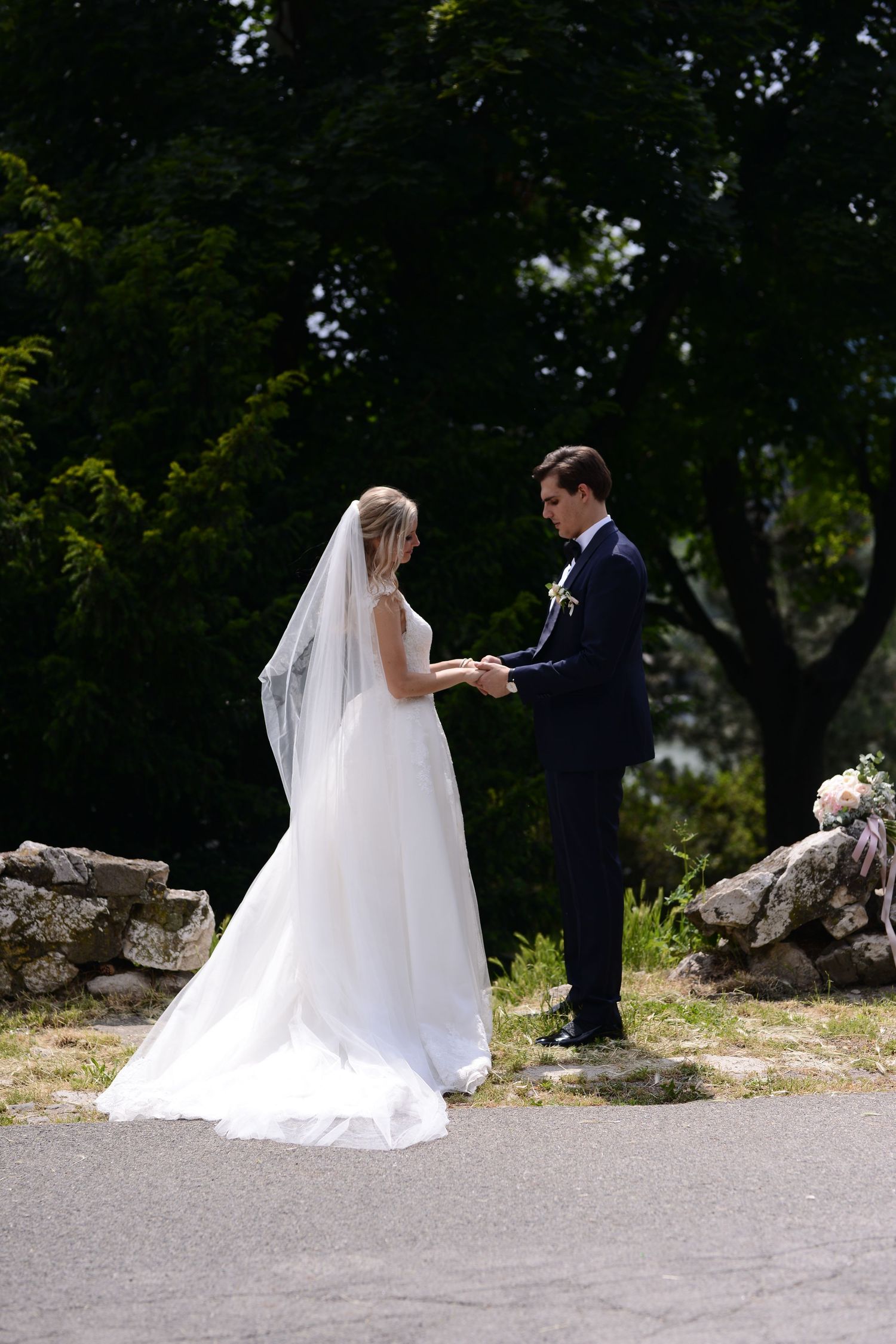 Bride and groom holding hands during an intimate outdoor ceremony, capturin a quiet promise and timeless wedding moment.