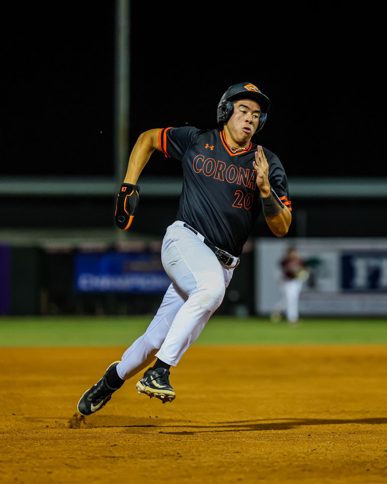 Baseball player #20 in Corona uniform sprints around the bases during a night game.
