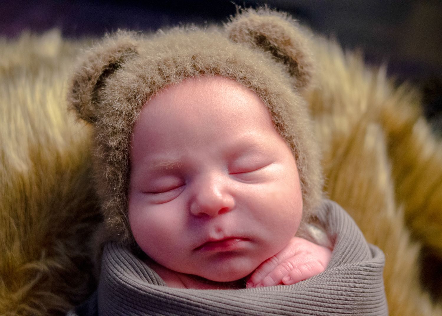 newborn boy dressed as teddy bear on fur blanket during professional newborn session in henderson texas