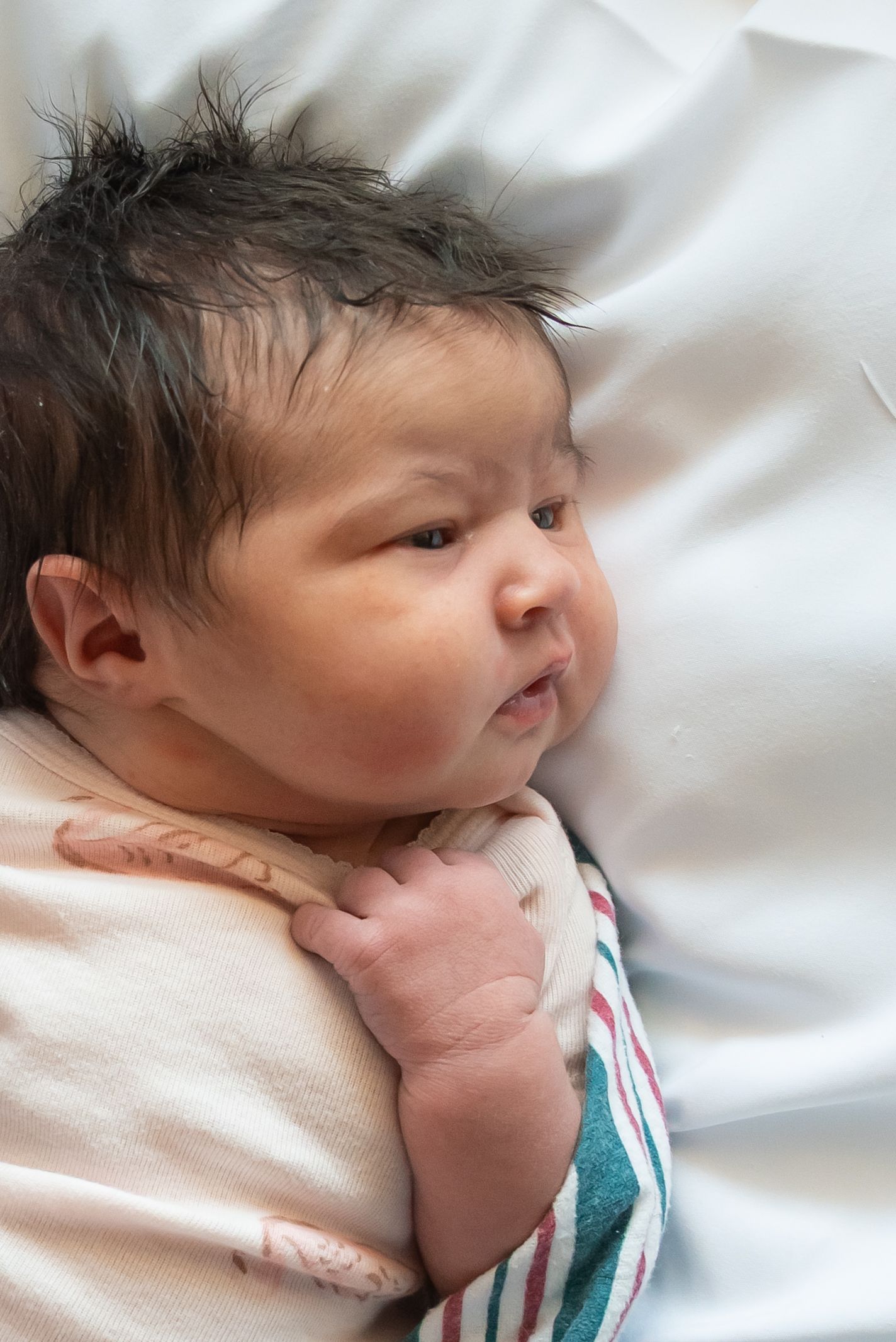 Chubby checked newborn girl laying on white blanket in home studio in Henderson texas