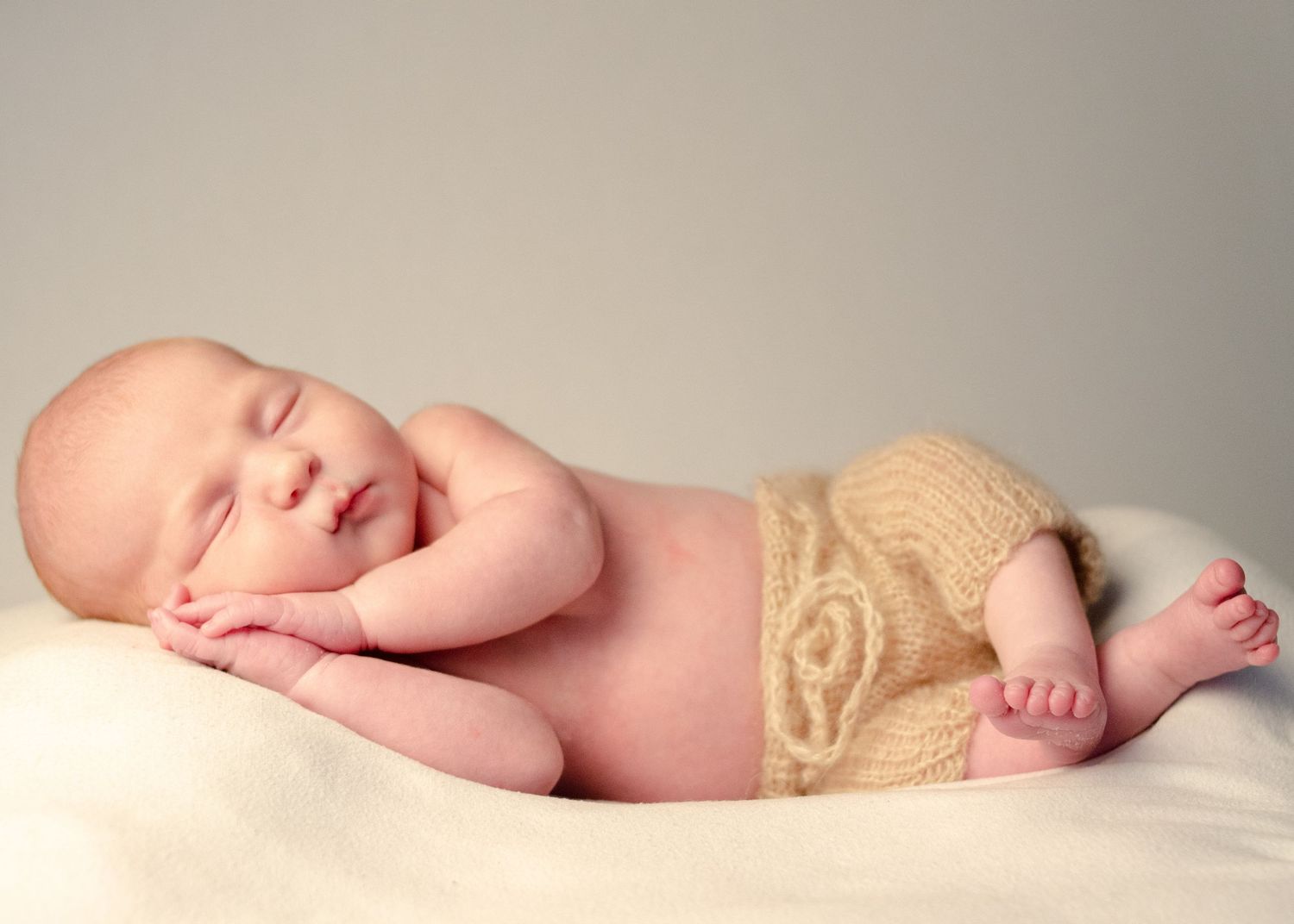 baby boy laying on white blanket in home studio in henderson texas