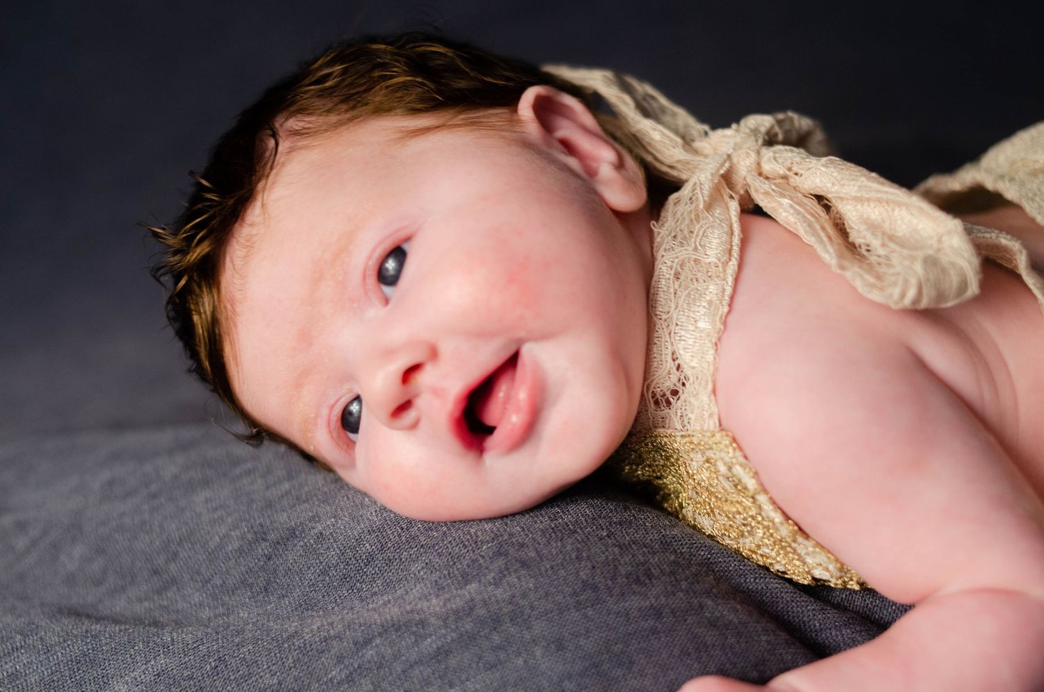 close up detail of smiling newborn wearing lace outfit