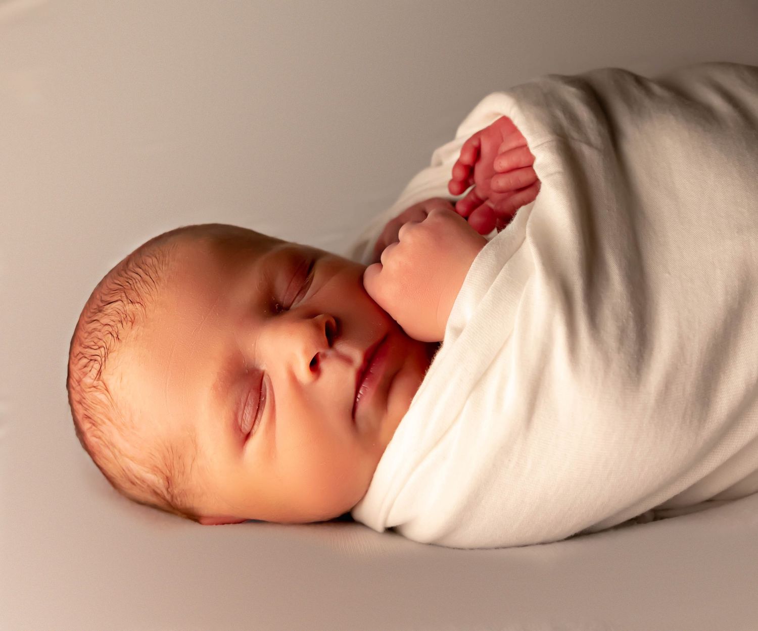 baby wrapped in white blanket and  close up micro detail shot of newborn toes and fingers in professional newborn studio in east texas
