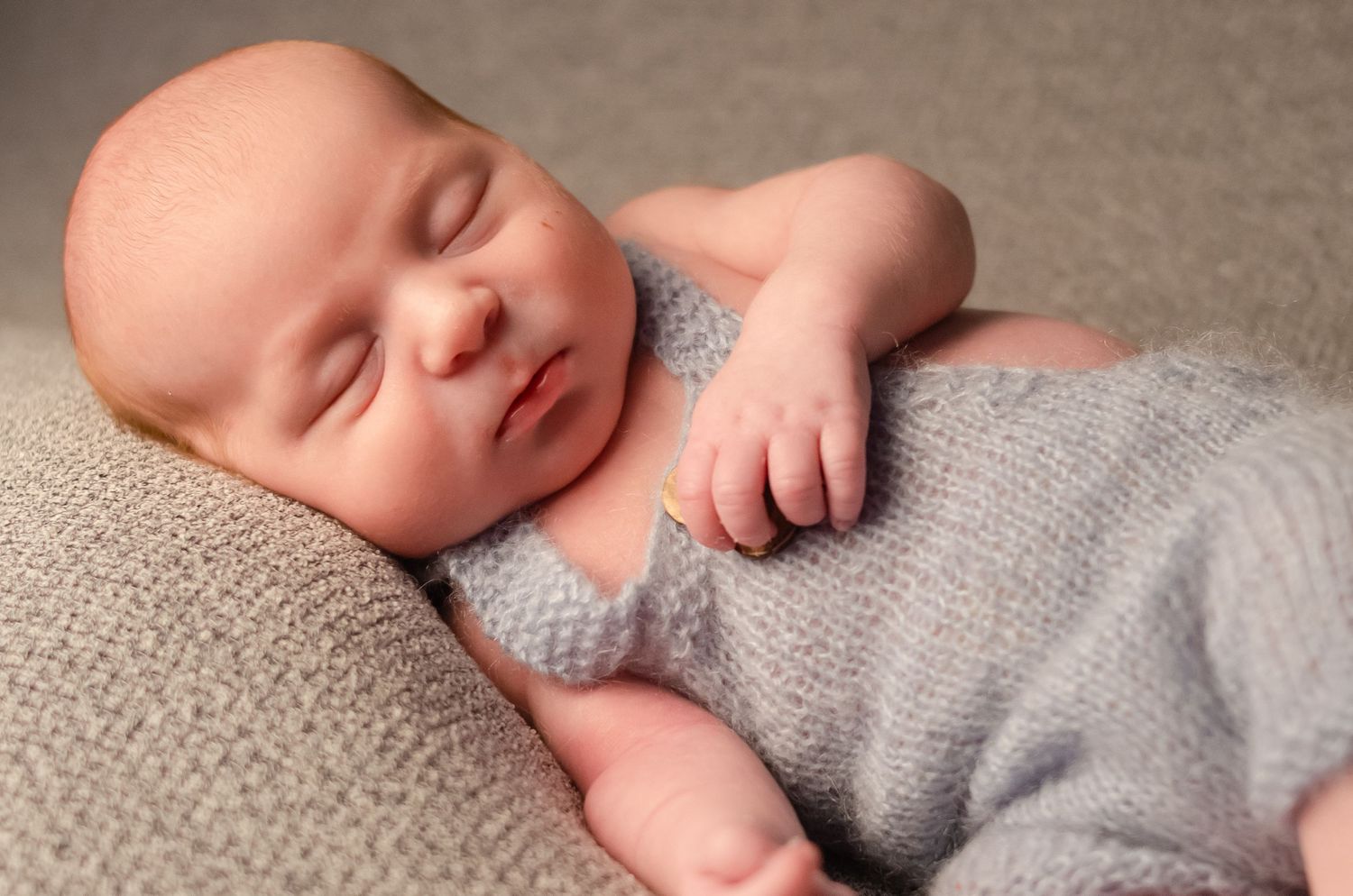 baby boy wearing prop overalls in home studio of professional photographer in henderson texas