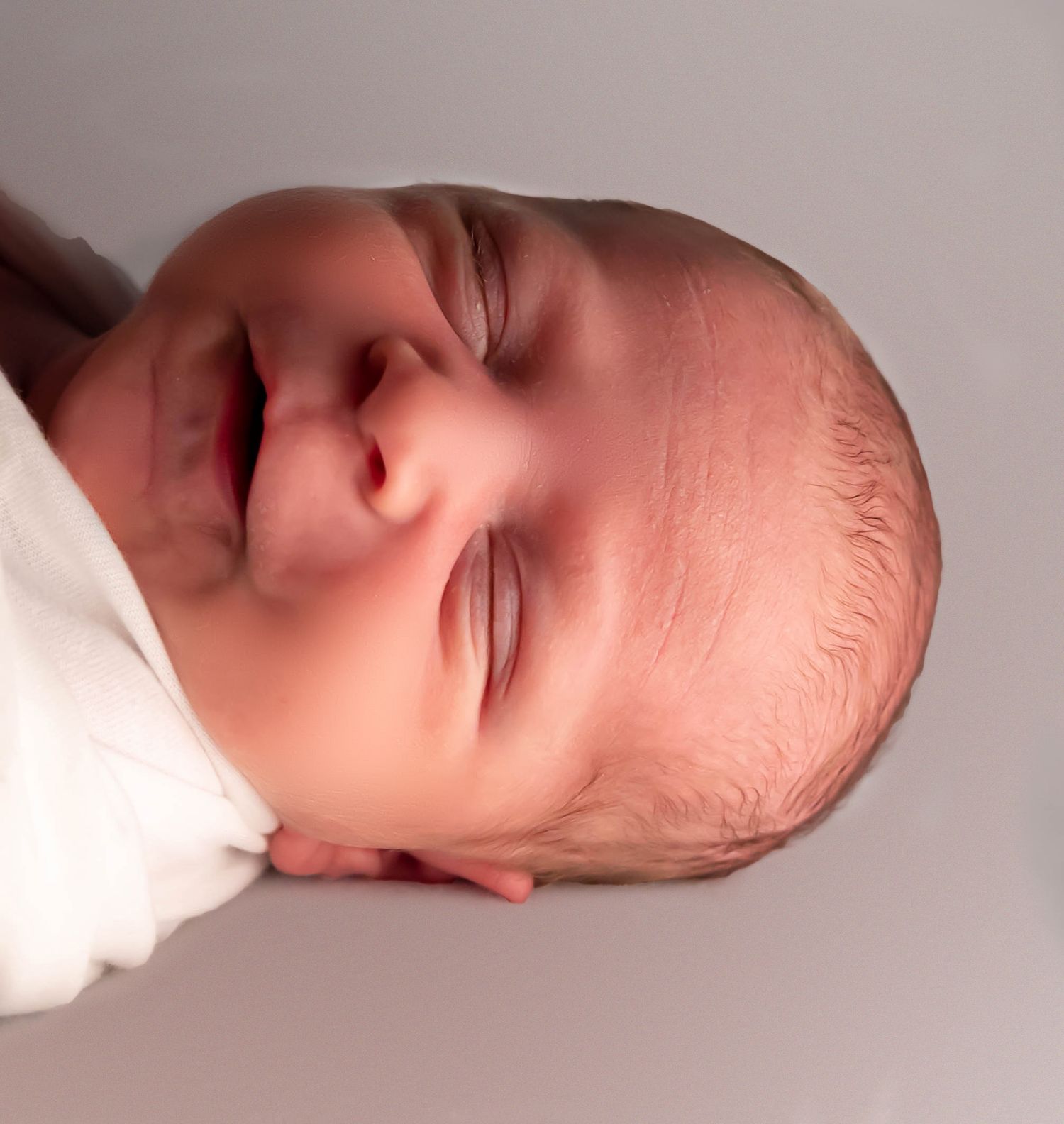 baby boy smiling in professional newborn portraits
