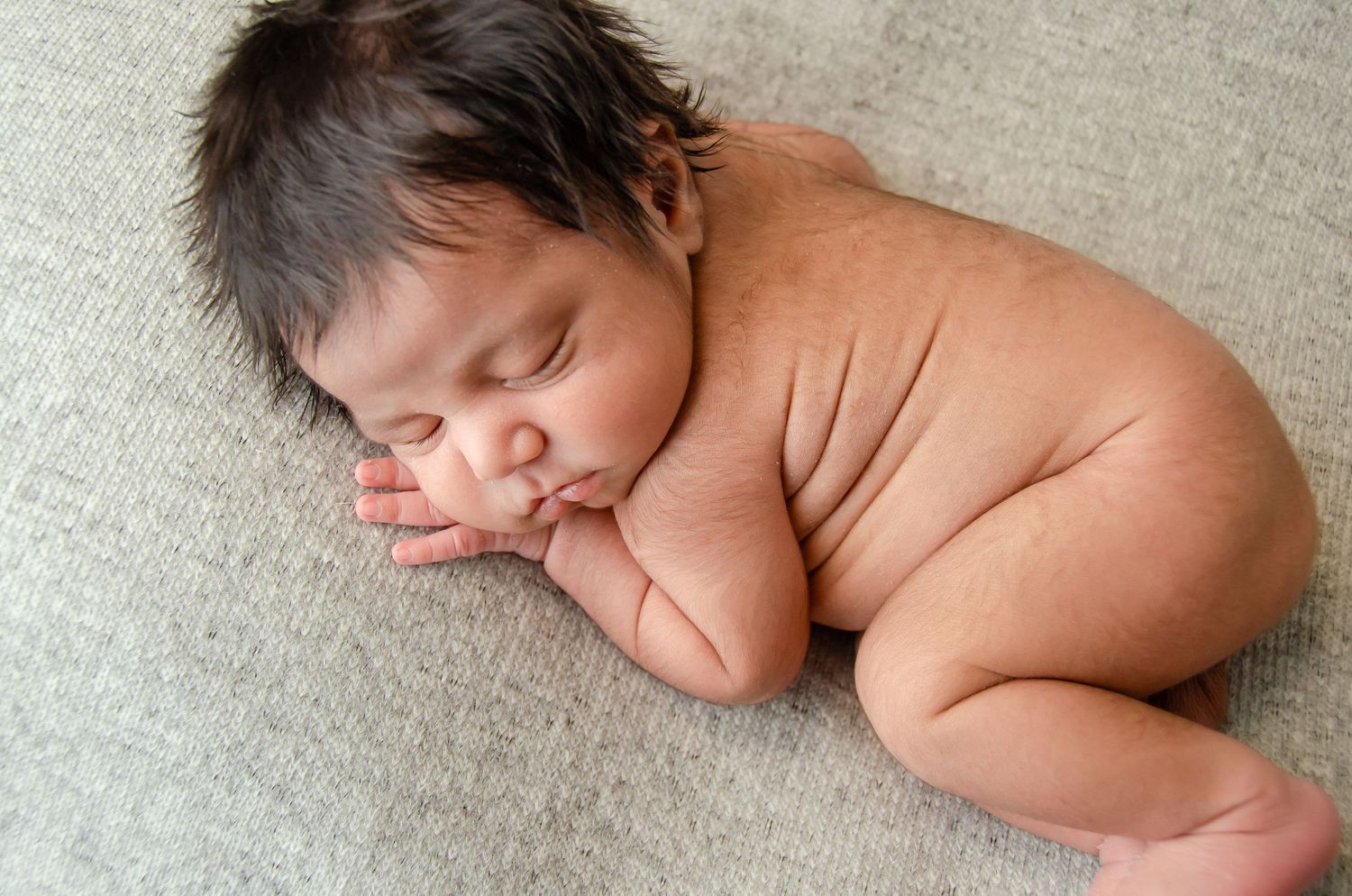 baby boy professionally posed on grey blanket by professional newborn photographer in east texas