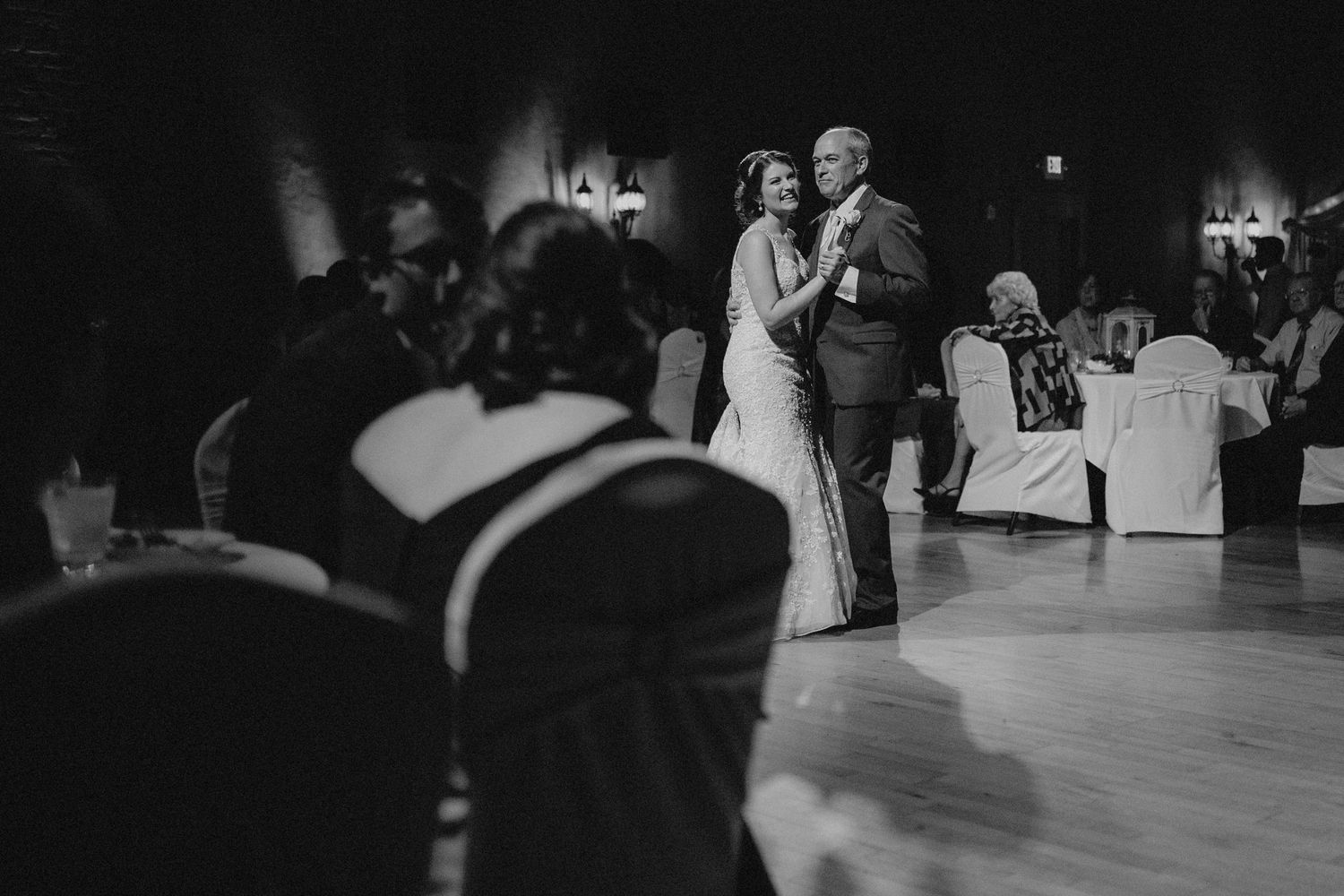 Bride and father share an emotional first dance on the ballroom floor at wedding reception.