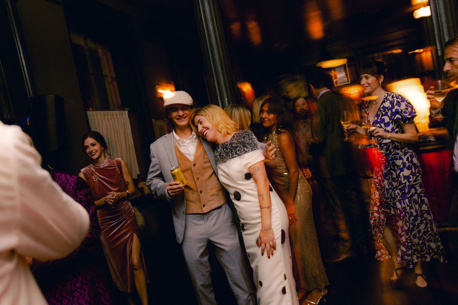 Couple sharing a tender moment on the dance floor surrounded by wedding guests at a reception.