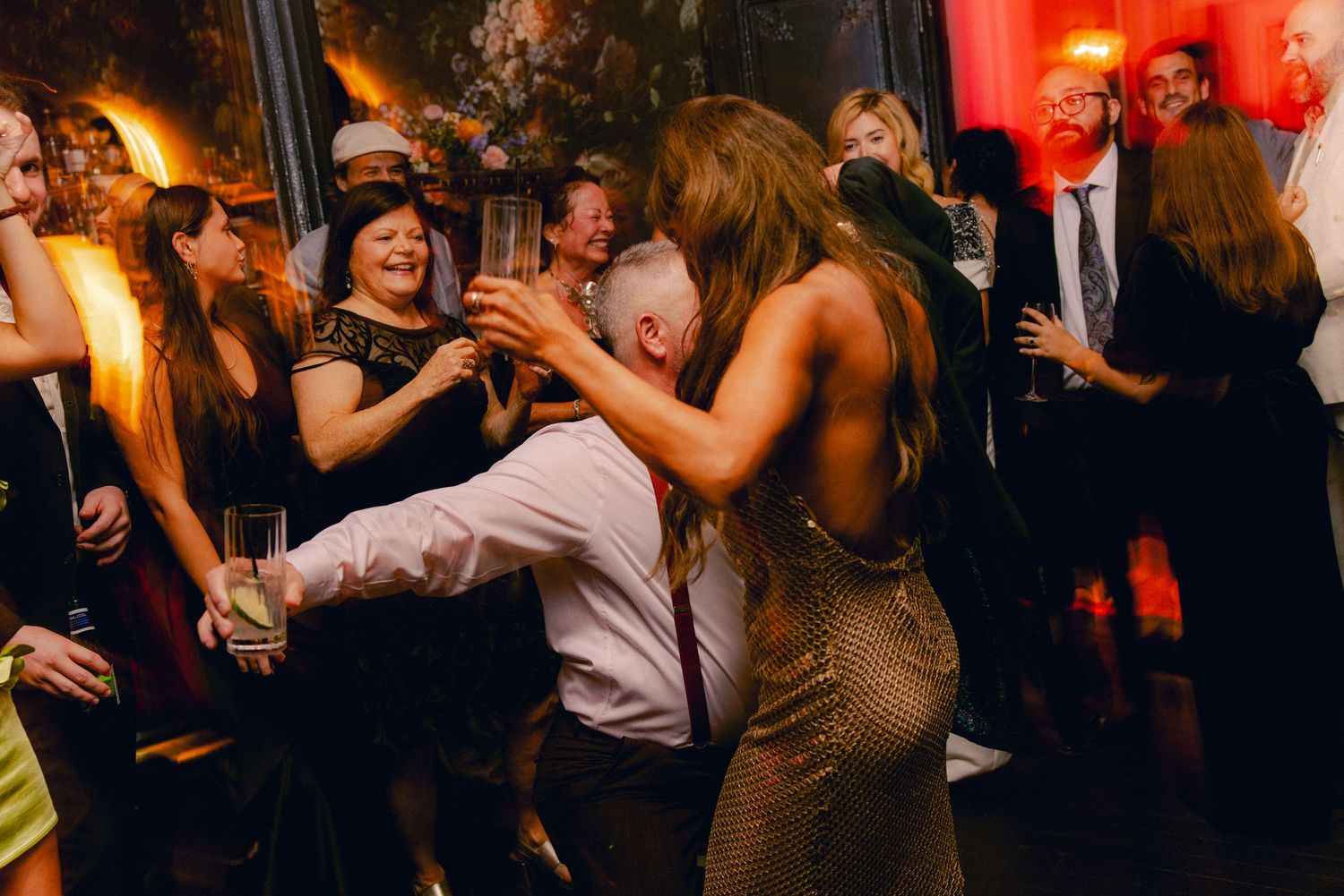 Guests dancing energetically on crowded dance floor at a lively evening wedding reception.