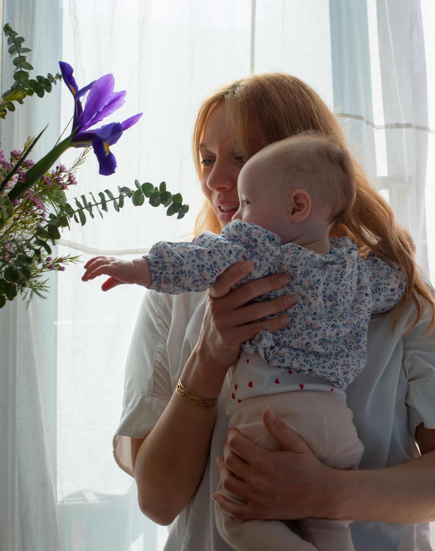 Baby and her mom looking at the flowers
