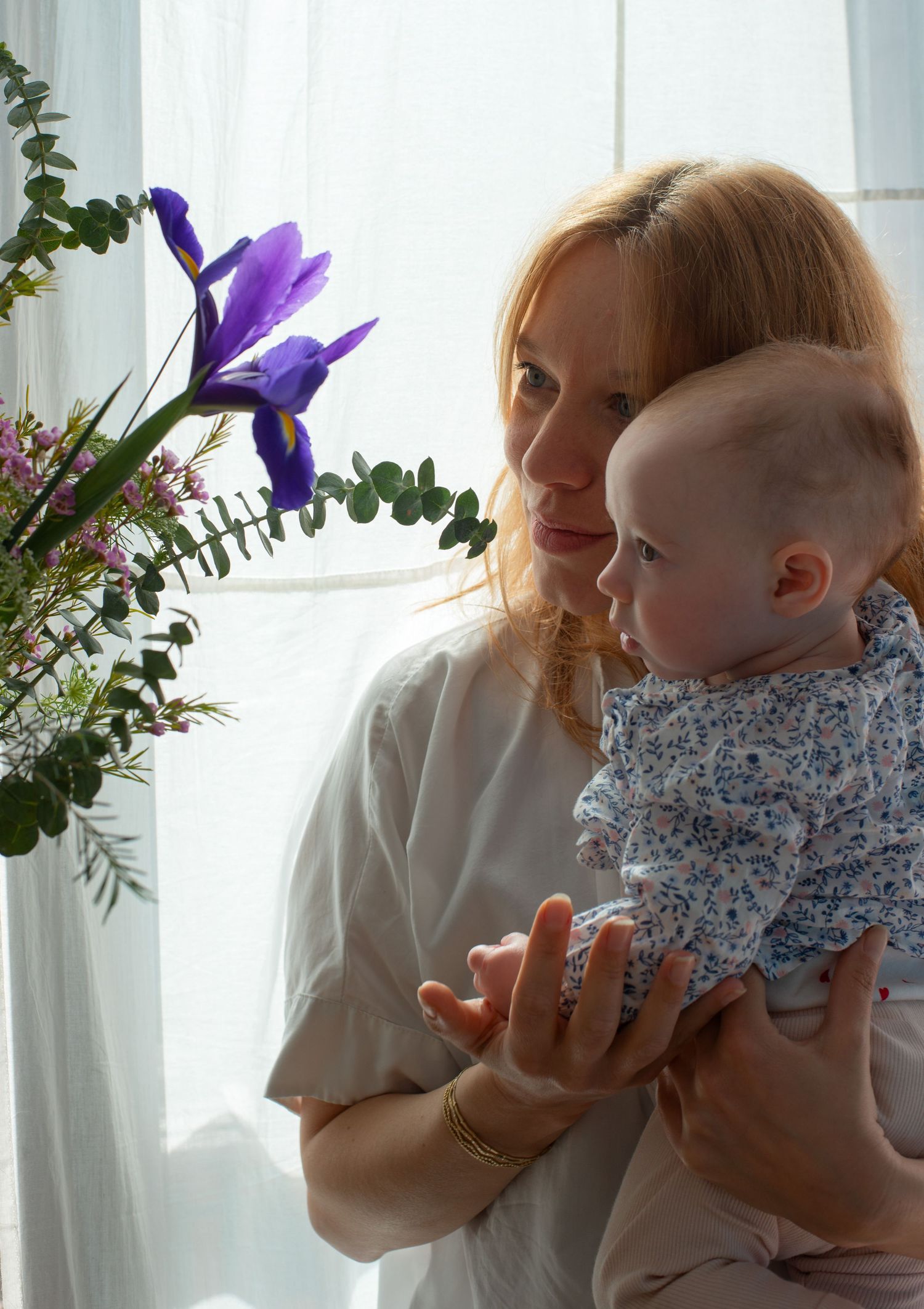 Baby and her mom looking at the flowers