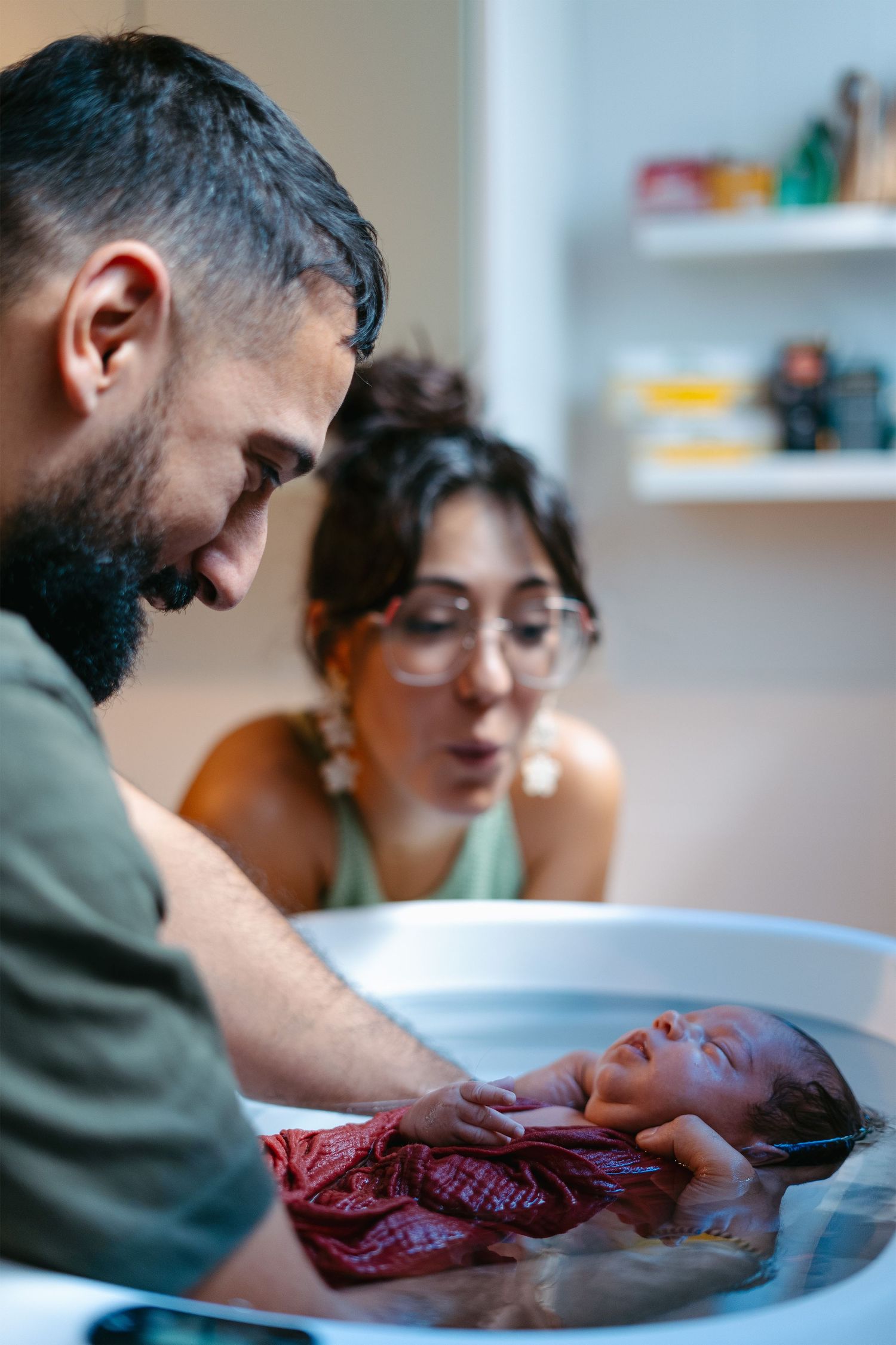 Parents bathing their baby