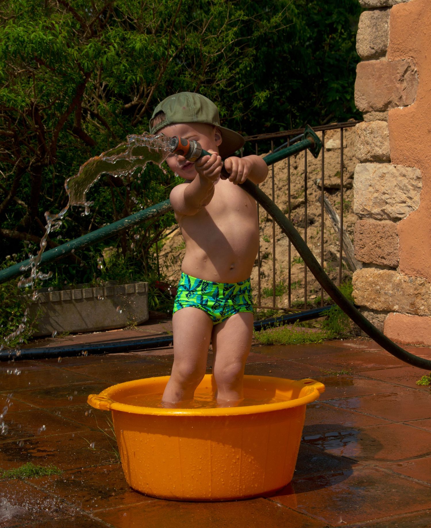 Little boy playing with the hose