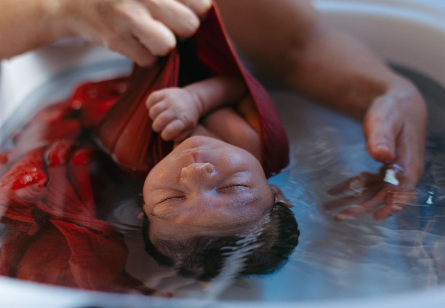 Parents bathing their baby