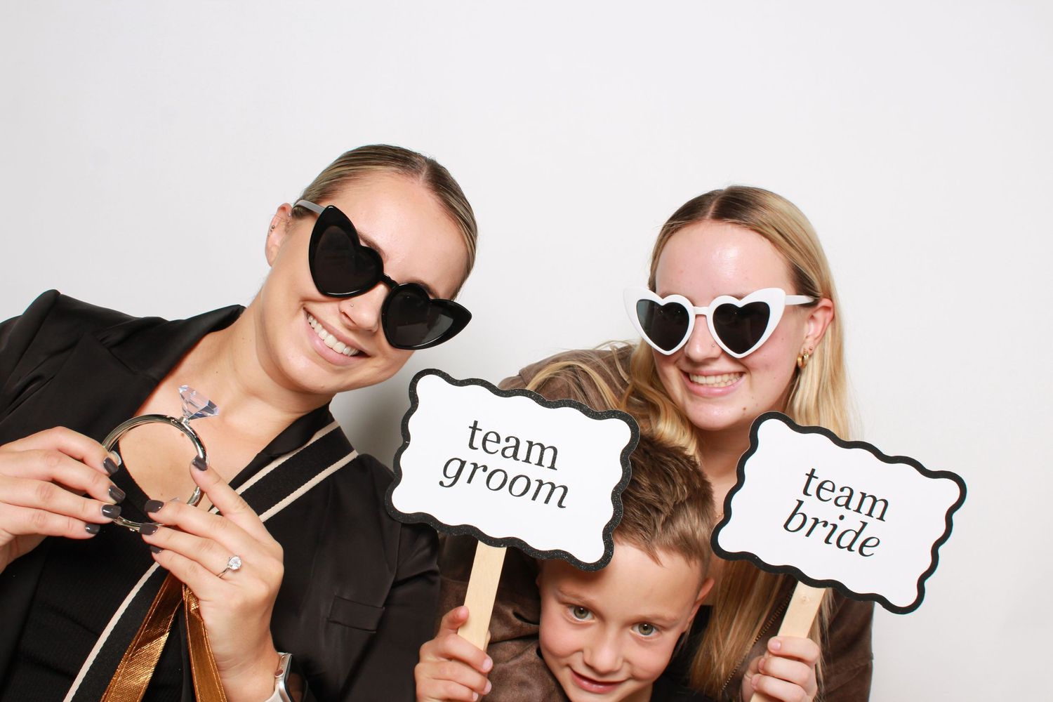 Wedding photo booth moment with guests holding Team Bride and Team Groom signs while wearing sunglasses. Perth WA Photo booth Hire Event Boo