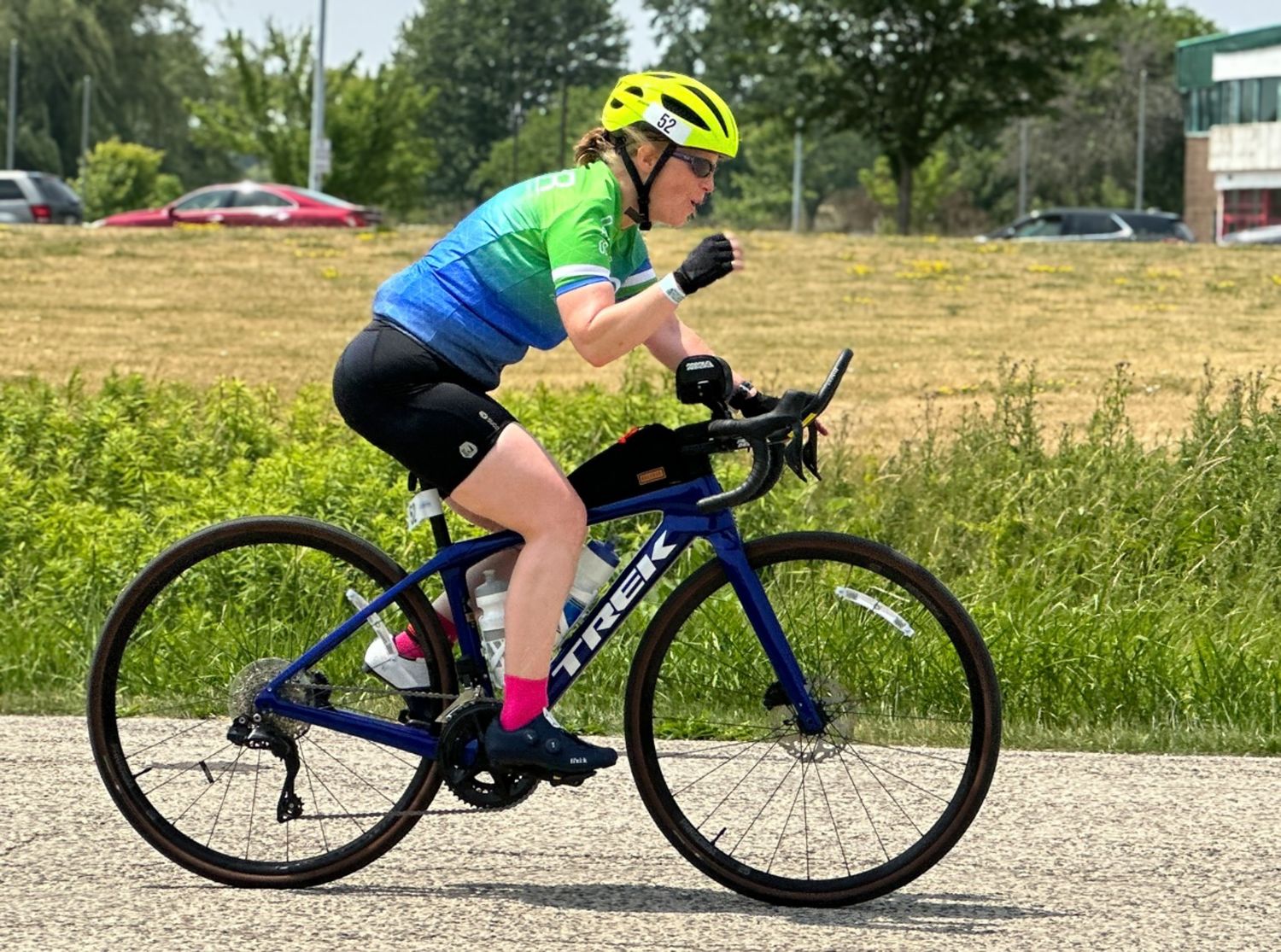 Female triathlete on a bike giving a fist pump for excitement