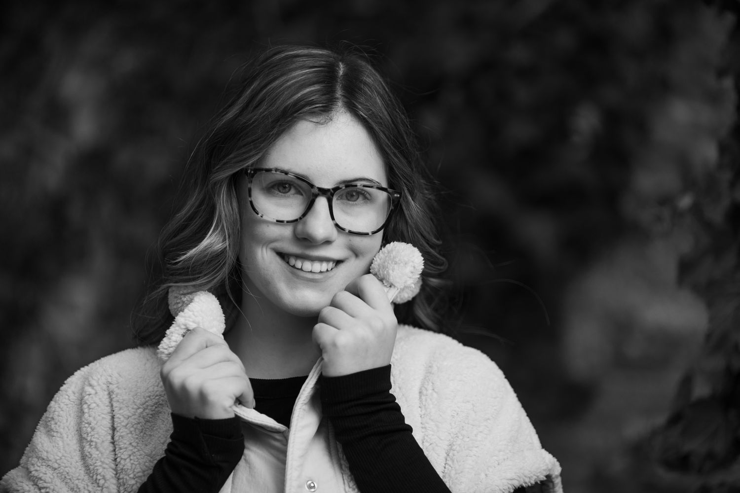 Black and white portrait series showing someone in glasses with various expressions and poses.