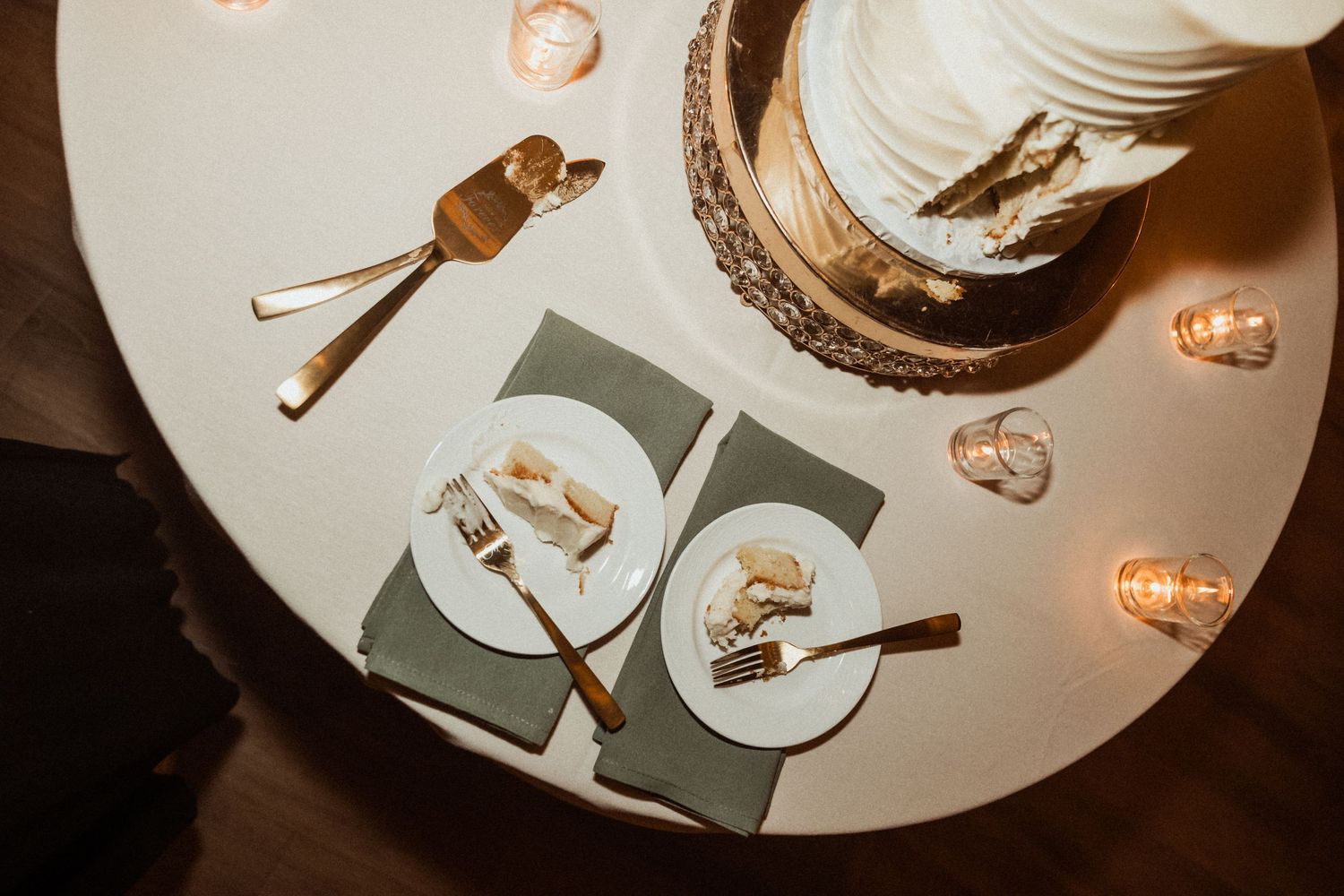 Overhead view of a dessert plate with chocolate cake crumbs and a used fork in soft lighting.