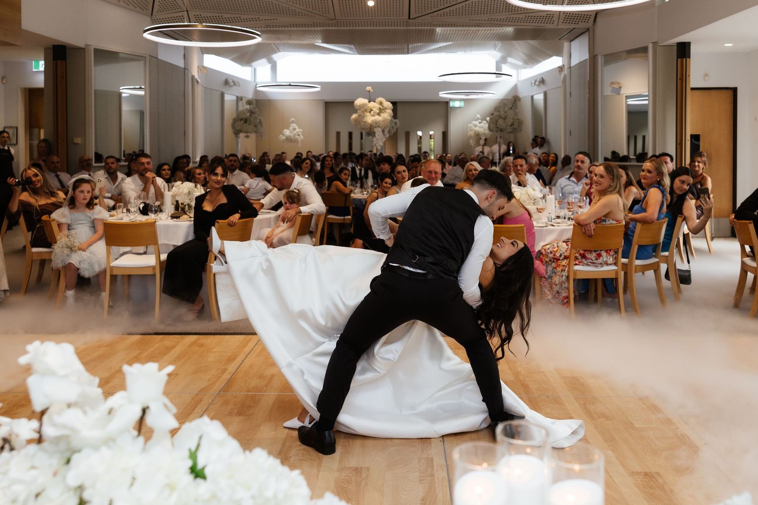 Wedding dance celebration with dramatic dips in modern reception venue.