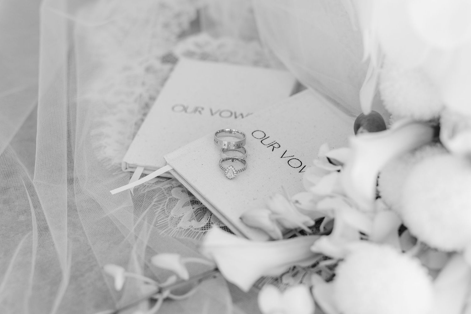A black and white close-up photo of wedding rings and a note on delicate fabric.