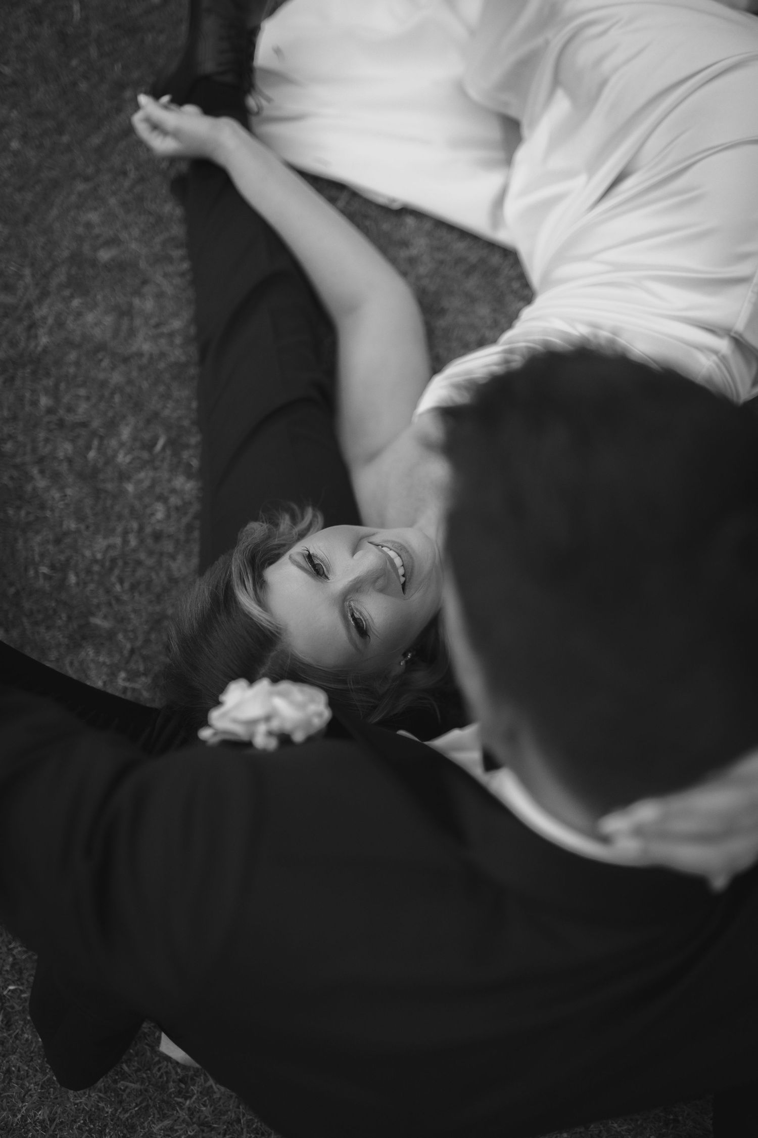 A black and white artistic photograph of a couple lying down in contrasting dark and light clothing.