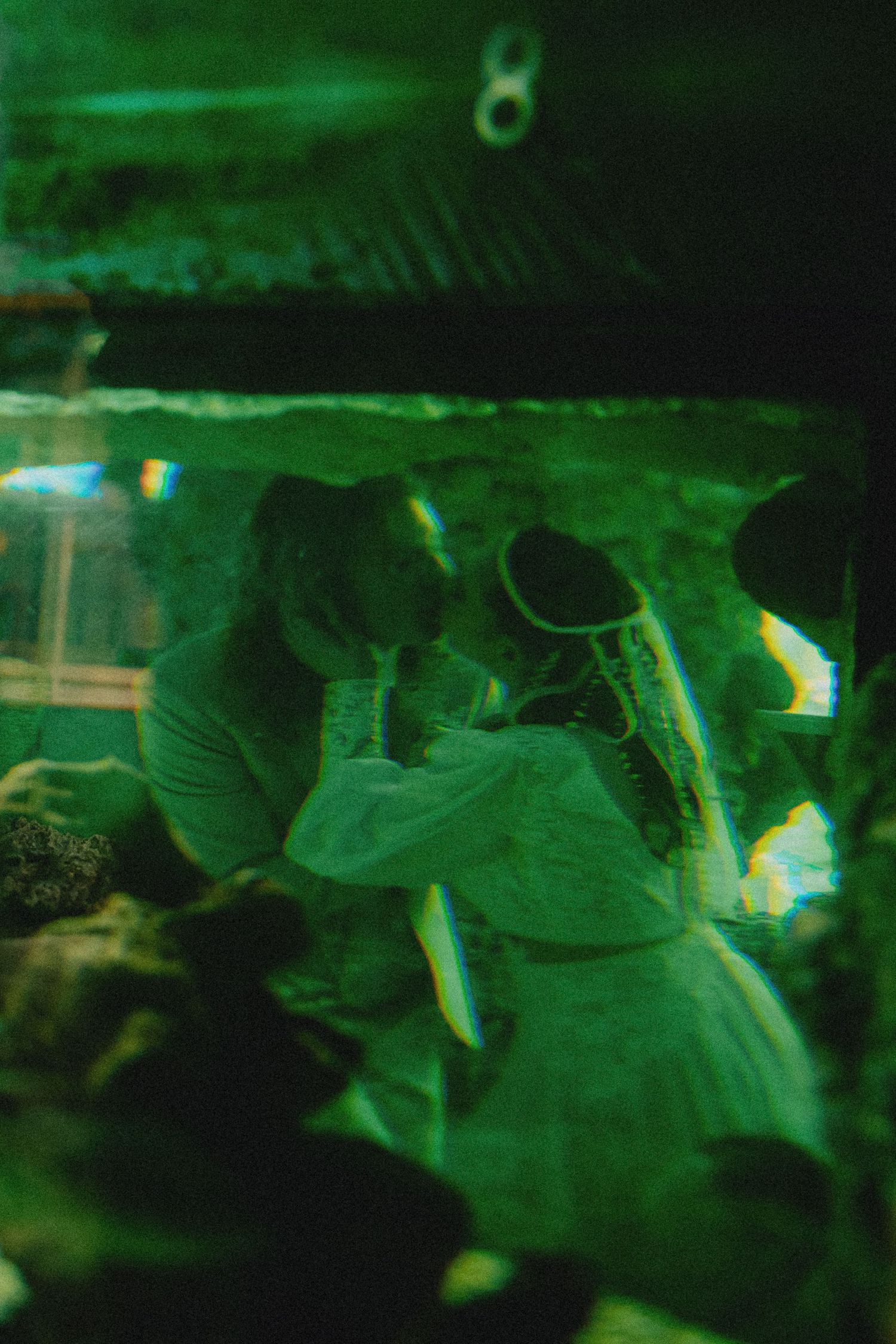 Green-tinted double exposure photo of a couple sharing a romantic moment, with ethereal light effects.