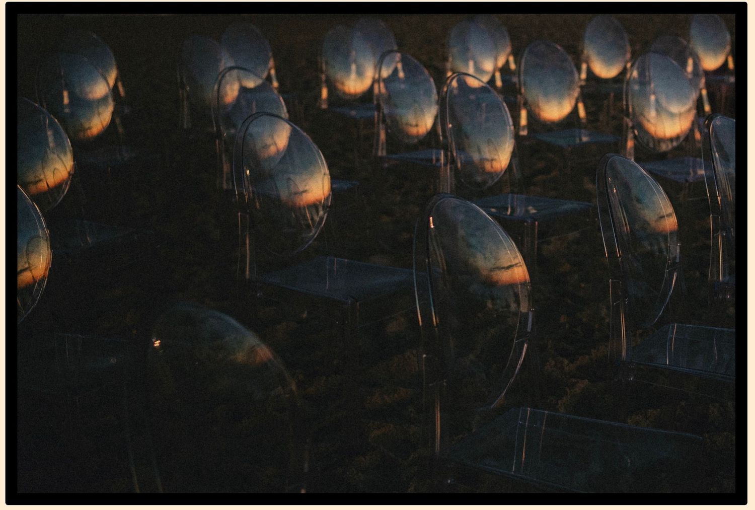 Rows of reflective metallic spheres capturing sunset light in an abstract artistic display.