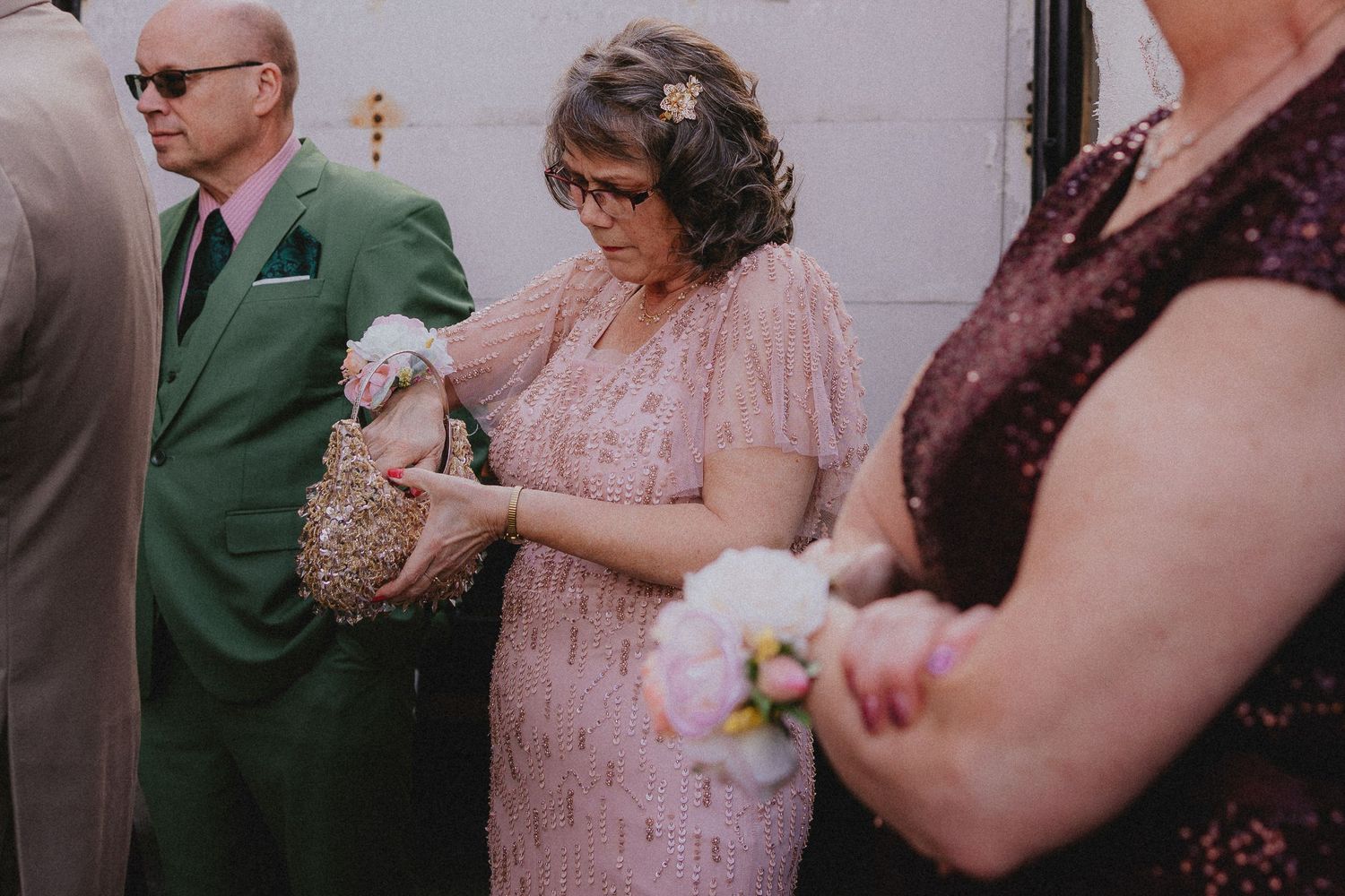 A group celebrates at a wedding reception, with people dancing and socializing in casual formal attire.