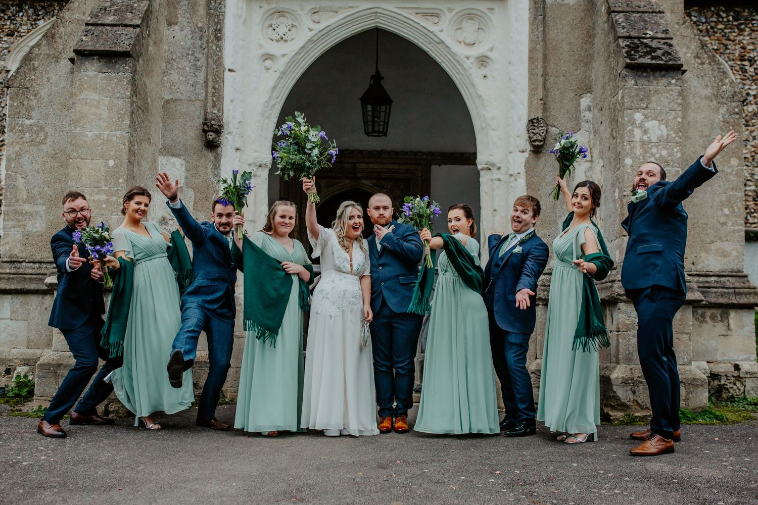 Bridal party fun pose outside Braughing Church Hertfordshire, Photographer RELM Photography