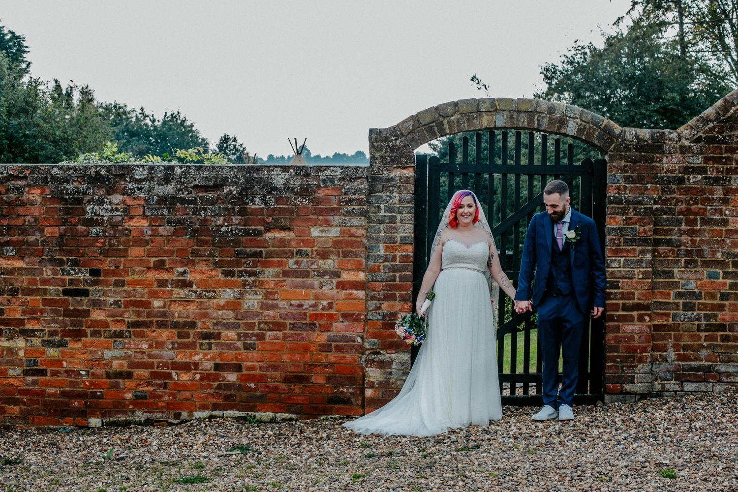 The bride and groom posing around the grounds of Lodge Farm House, Hertfordshire