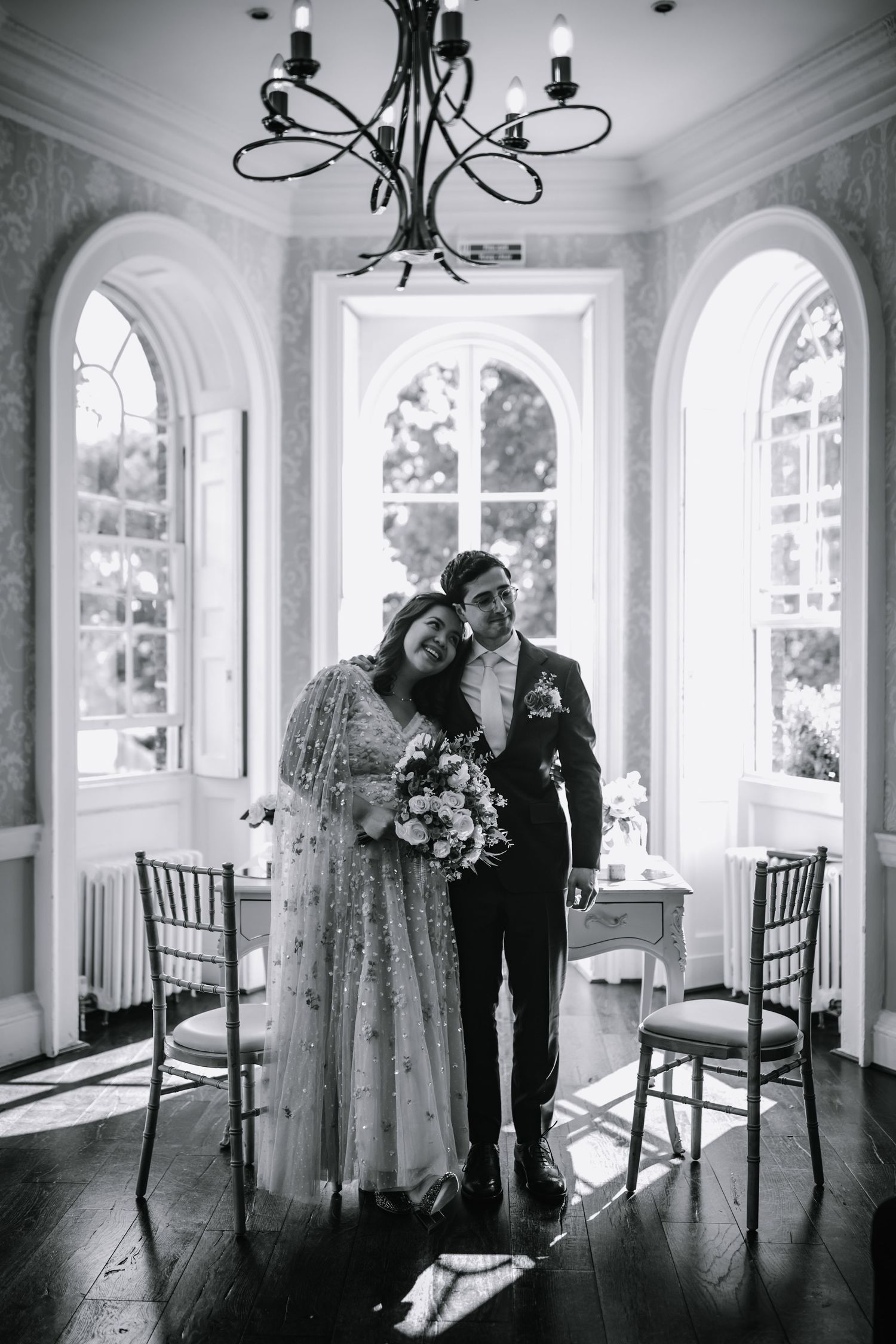 Newly married couple pose after their ceremony, smiling with joy.