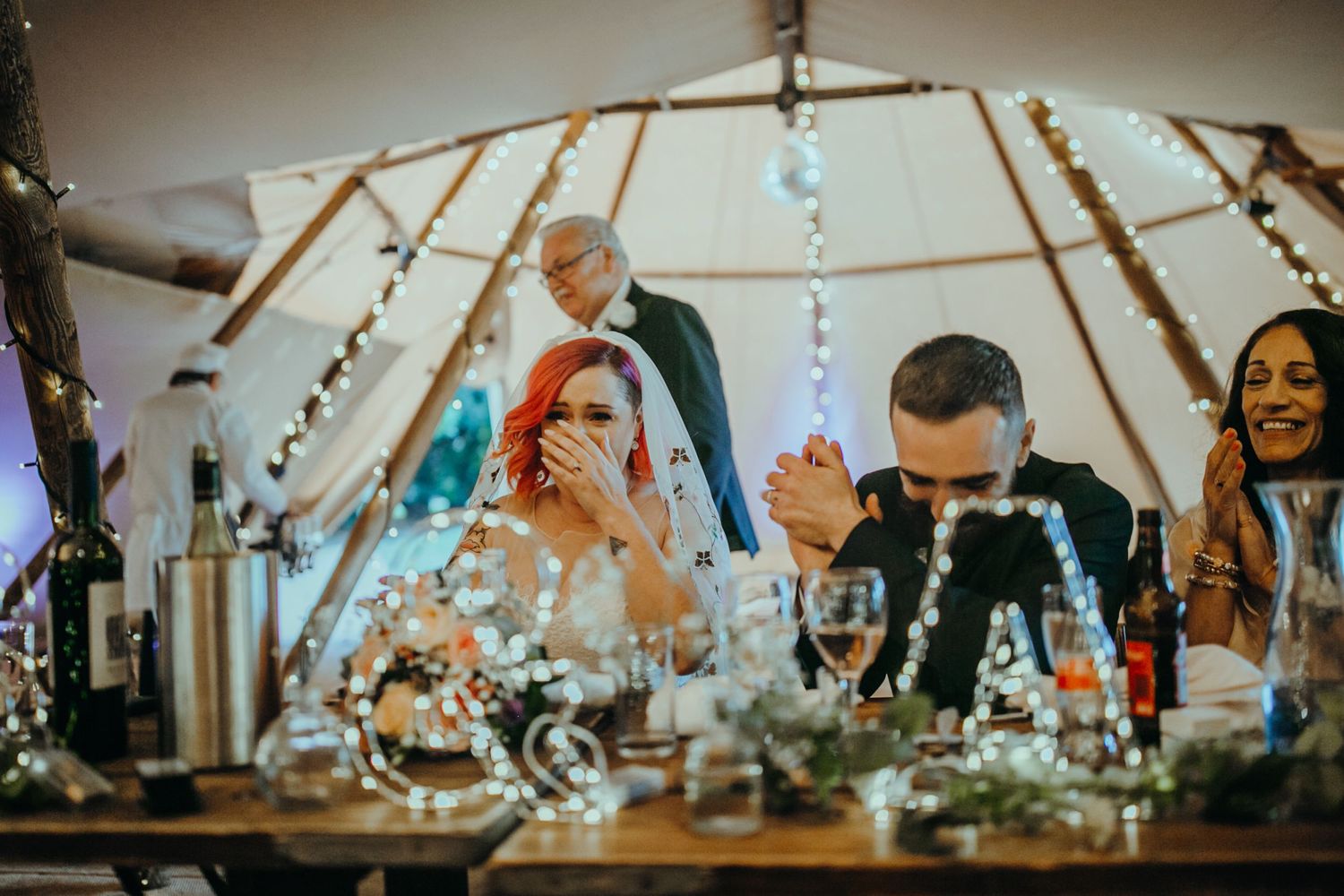 Bridal giggles – The bride laughs with joy as a funny wedding speech brings smiles to the guests.