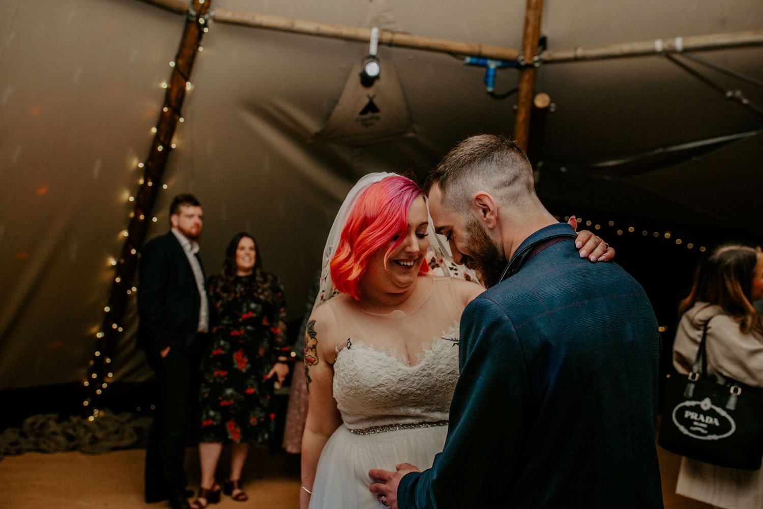 A perfect moment – The newlyweds share a private smile as they dance together, the warm fairy lights creating an intimate atmosphere.