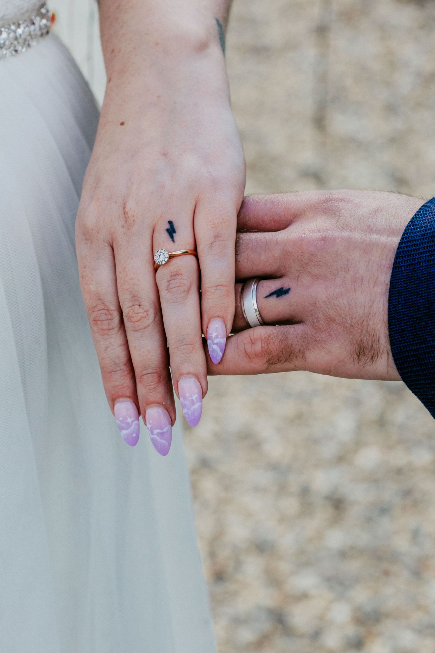 Bride and groom showcase their matching lighting bolt tattoos below their wedding bands, Harry Potter fans