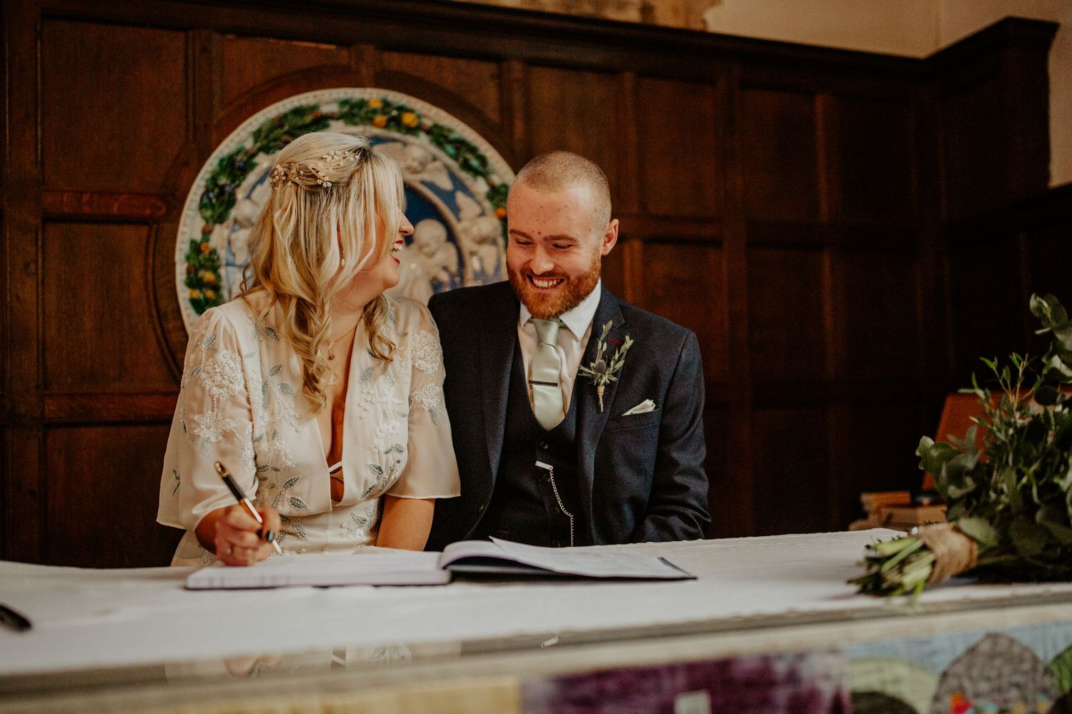 Bride and groom signing the registry at Braughing Church Hertfordshire, Photographer RELM Photography