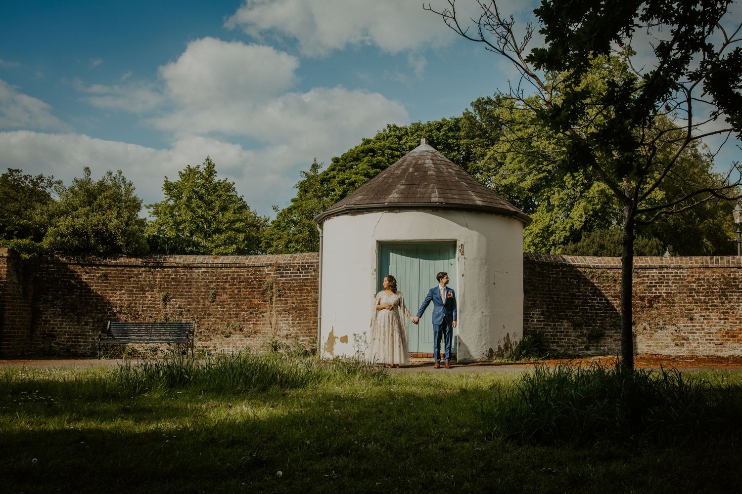Bride and groom embrace in the gardens of Morden Park, London, during their wedding portraits.