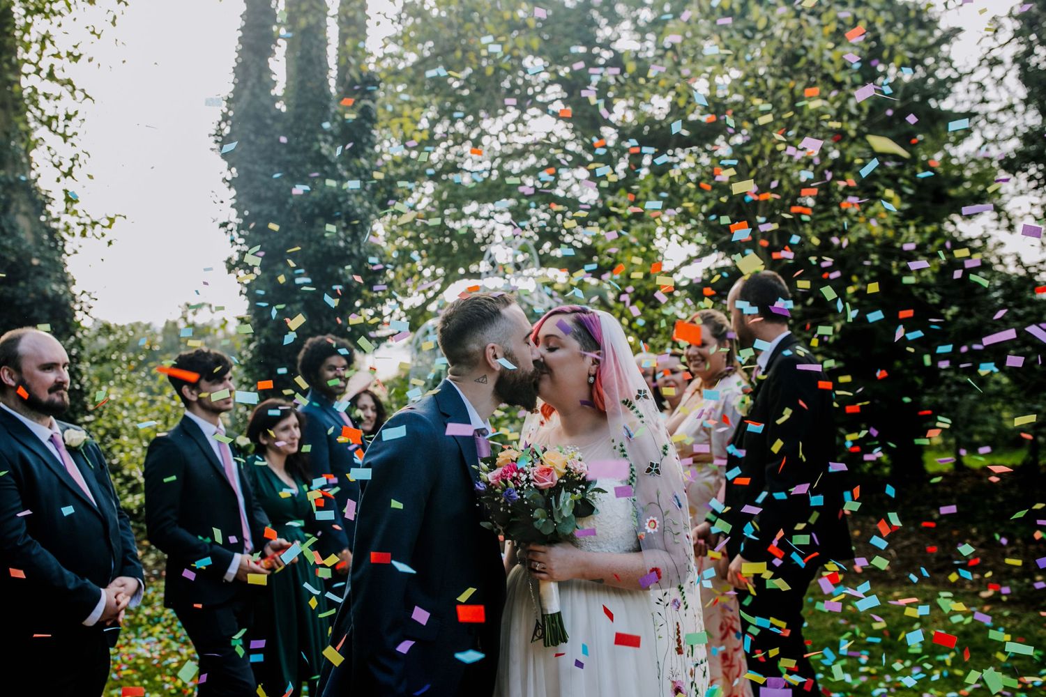 Surrounded by love – The couple beams as friends and family shower them with confetti.