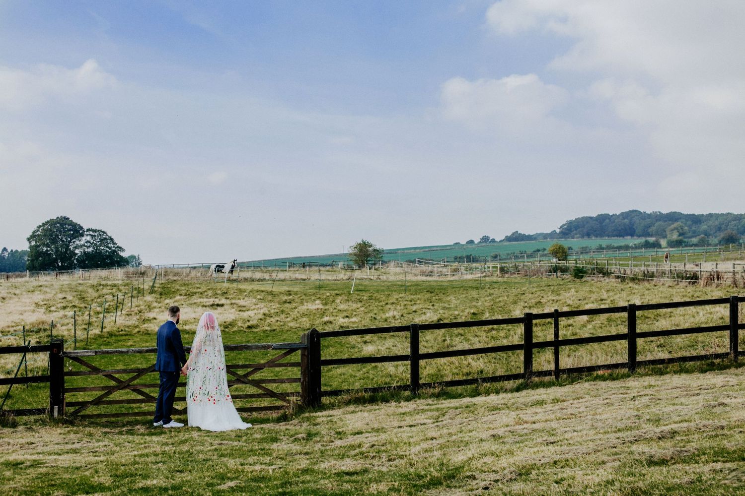 The bride and groom share a quiet moment overlooking the fields of Lodge Farm House, Hertfordshire