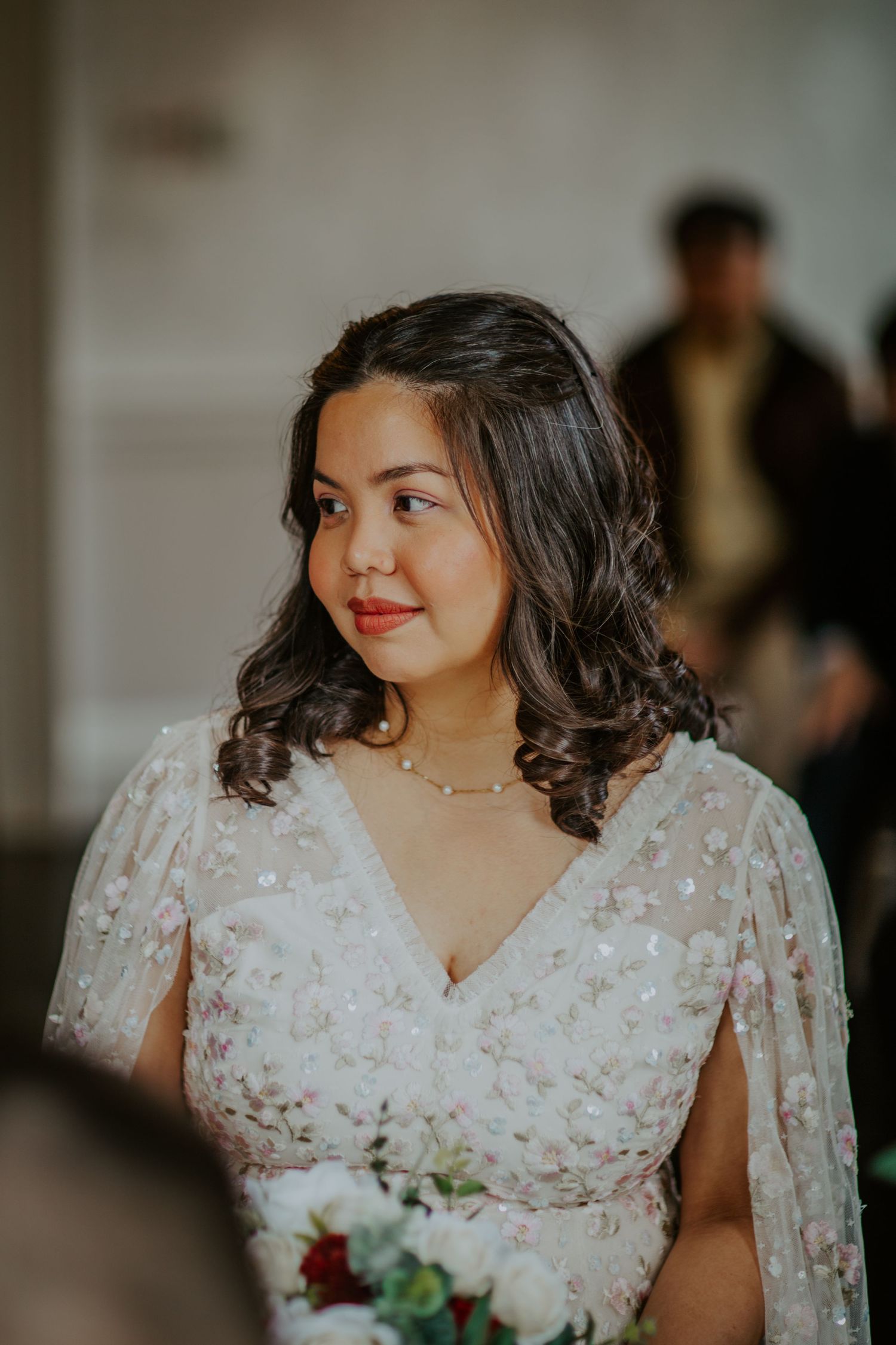 Bride smiles as groom reads vows in the ceremony at Morden Park.