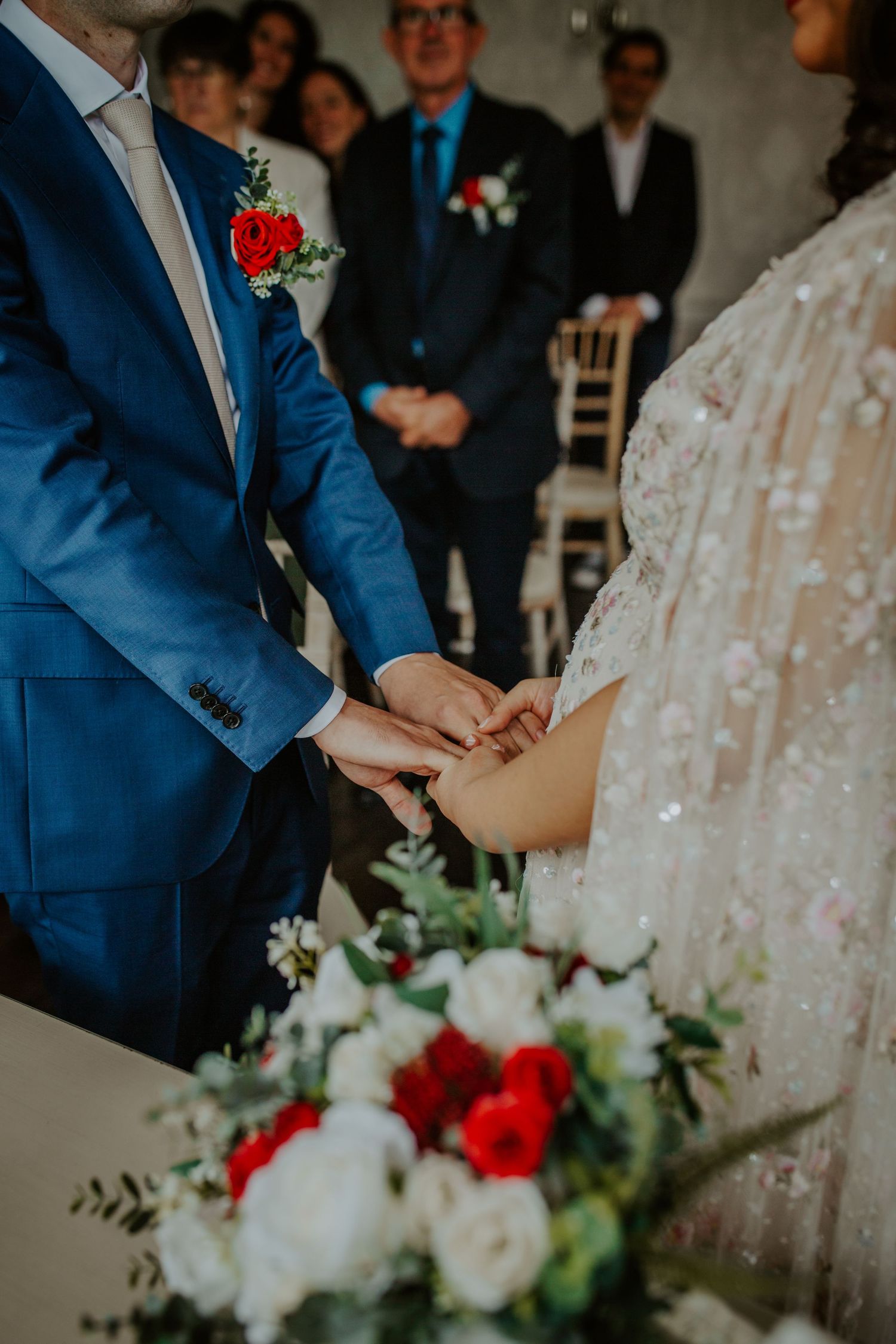 Bride and groom hold hands as they stand together during their wedding ceremony.