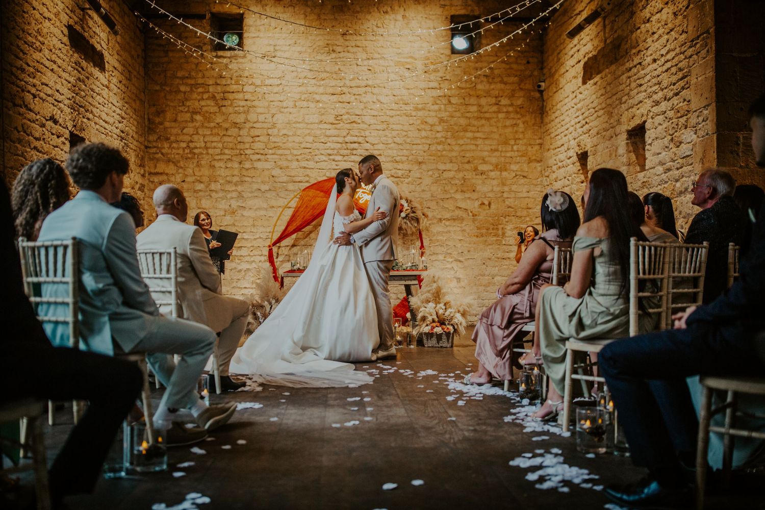 Bride and groom first kiss at their wedding ceremony - Lapstone Barn – Chipping Campden, The Cotswolds