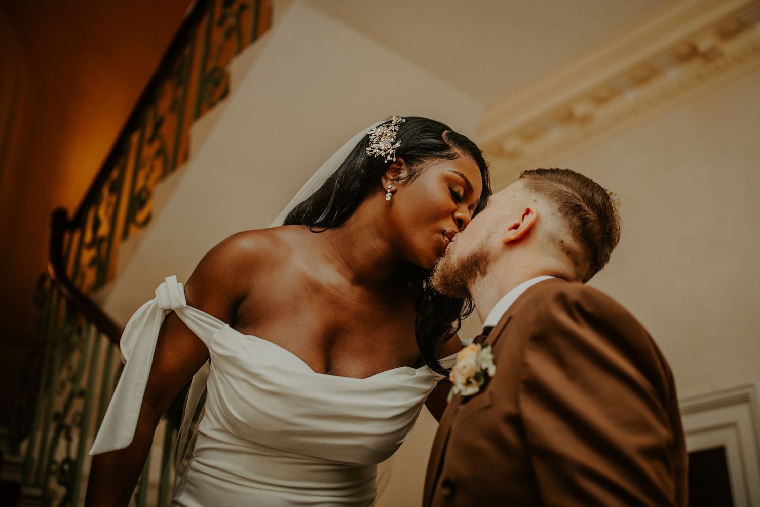 Bride and Groom kissing on the staircase after their wedding ceremony at Morden Park House - London - RELM Photography